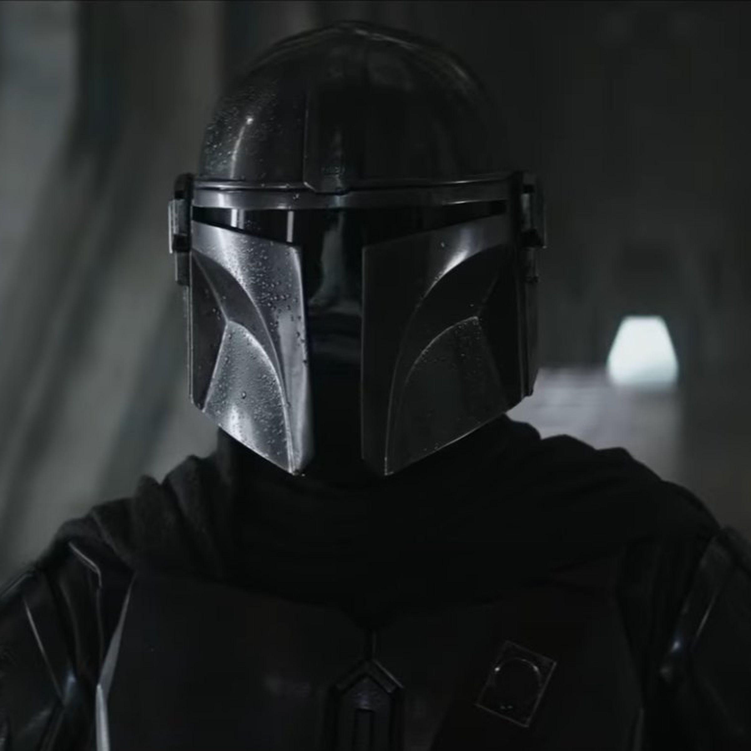Still image of The Mandalorian, with visible droplets of water on his shiny helmet