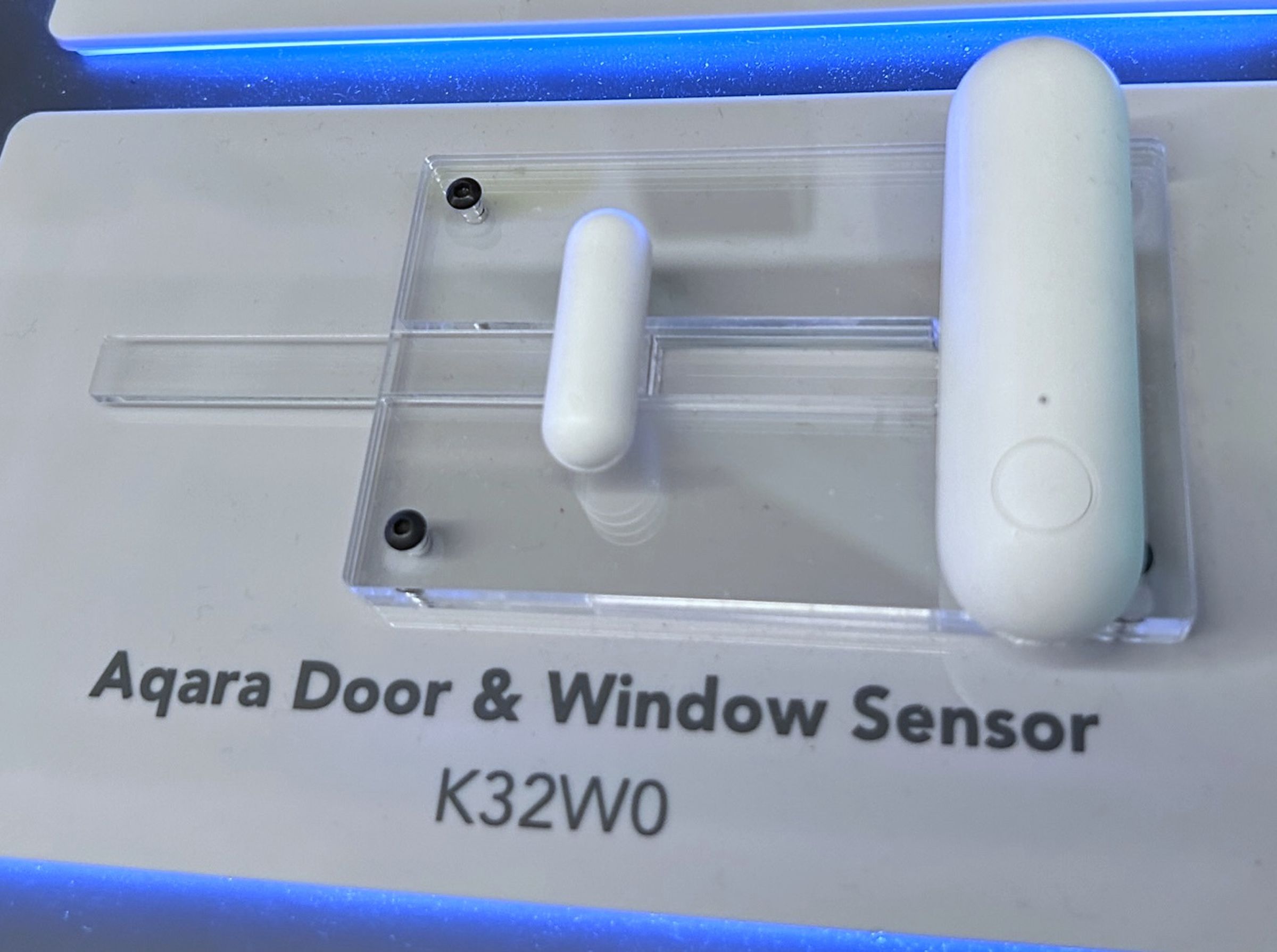 Photo of the Aqara Door and Window Sensor P2 mounted to a plastic demonstration board.