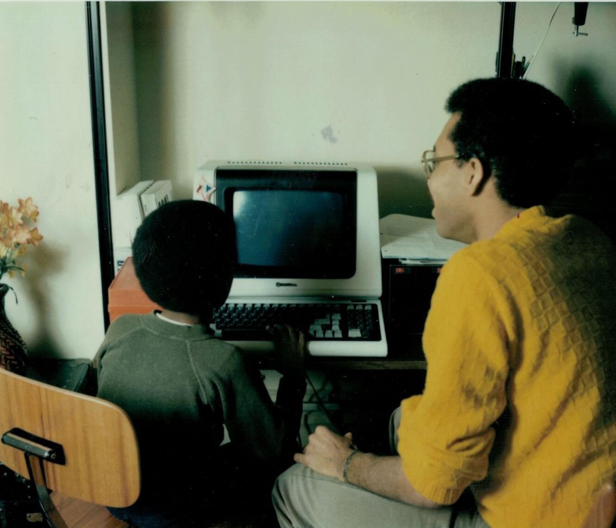 adult and child looking at computer together at desk