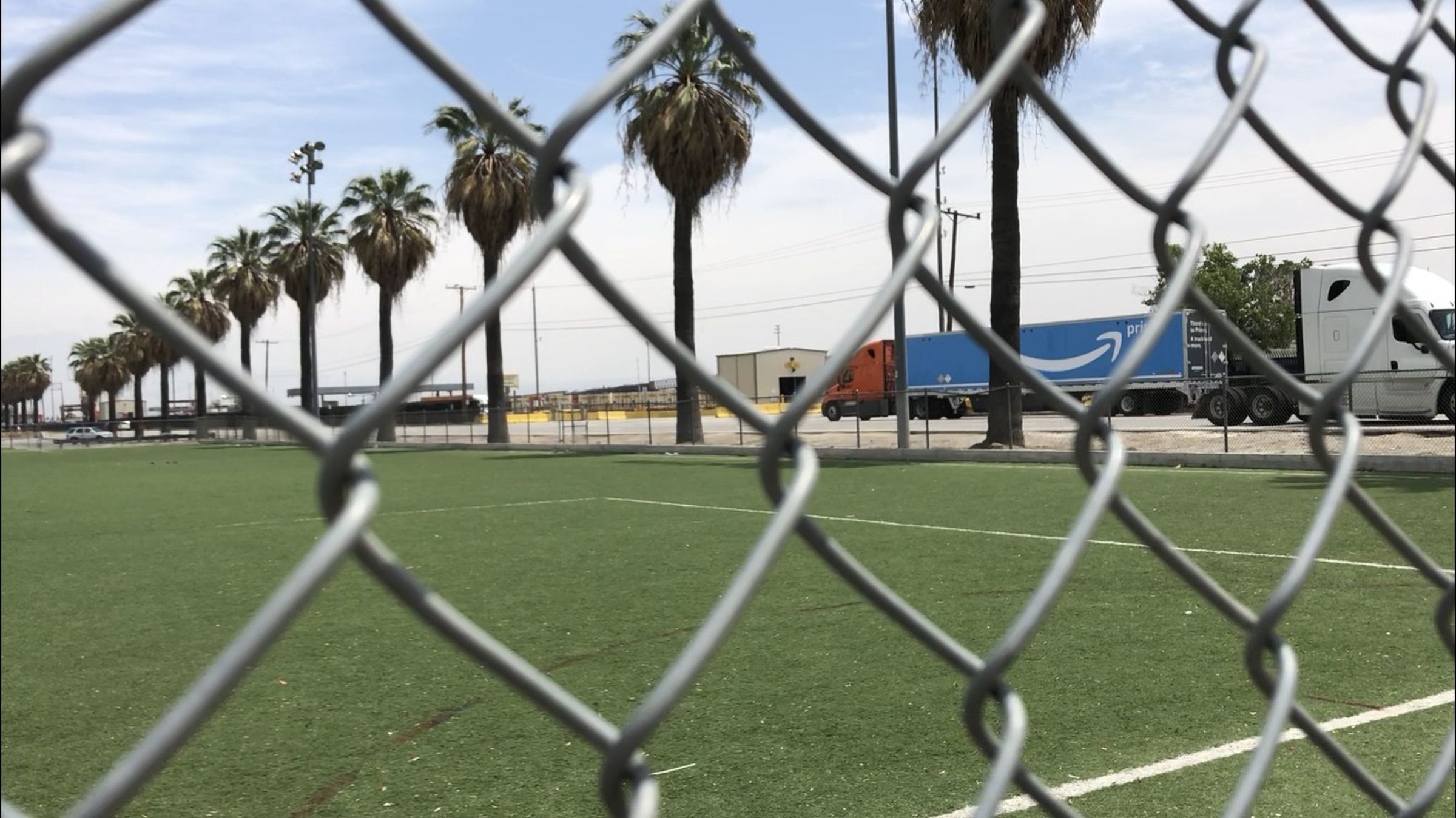 An Amazon Prime truck drives into the BNSF rail yard. The rail yard sits across the street from a soccer field and community center in San Bernardino, California and attracts a steady stream of truck traffic.