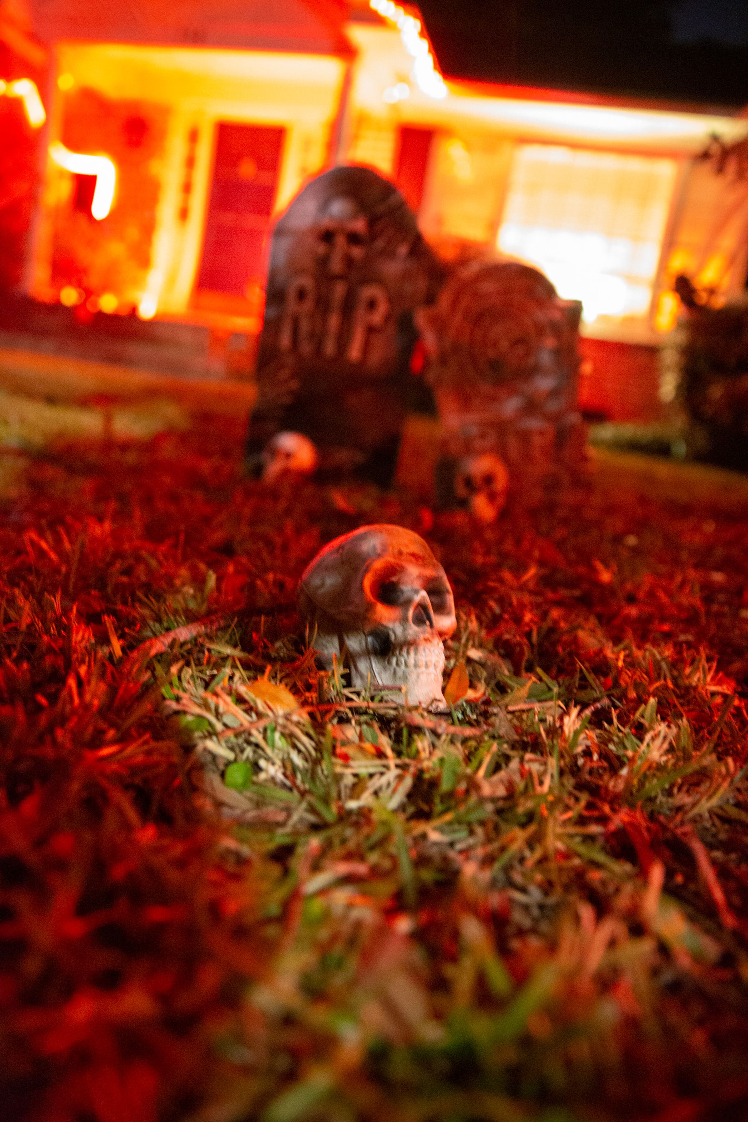 A plastic skull in front of fake graves in a front yard