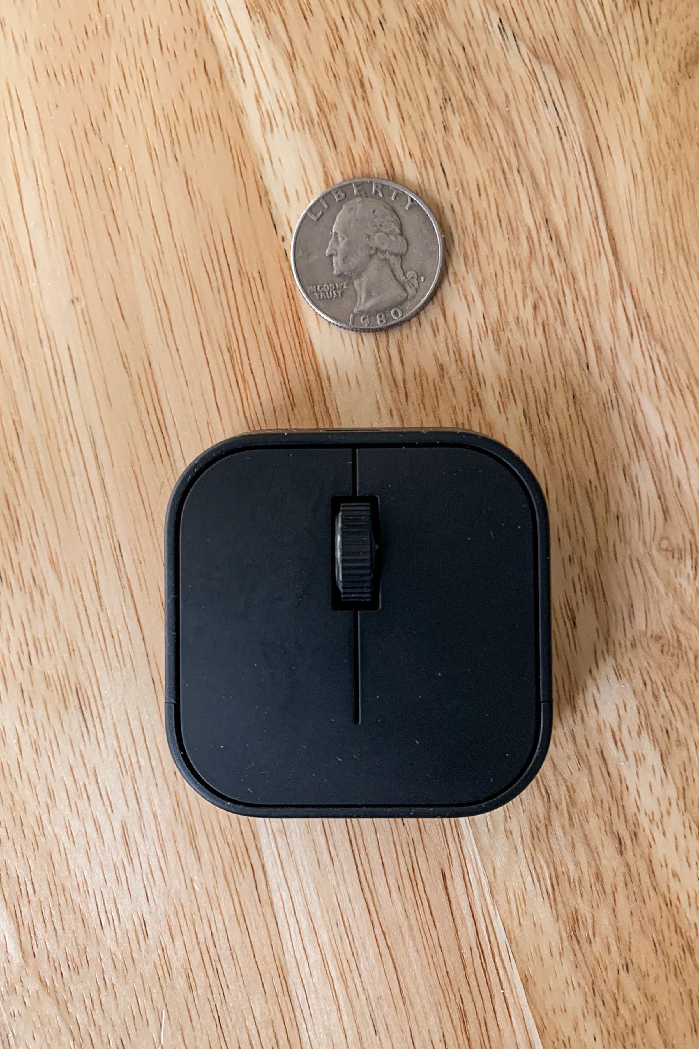 Small square mouse with buttons and scroll wheel.