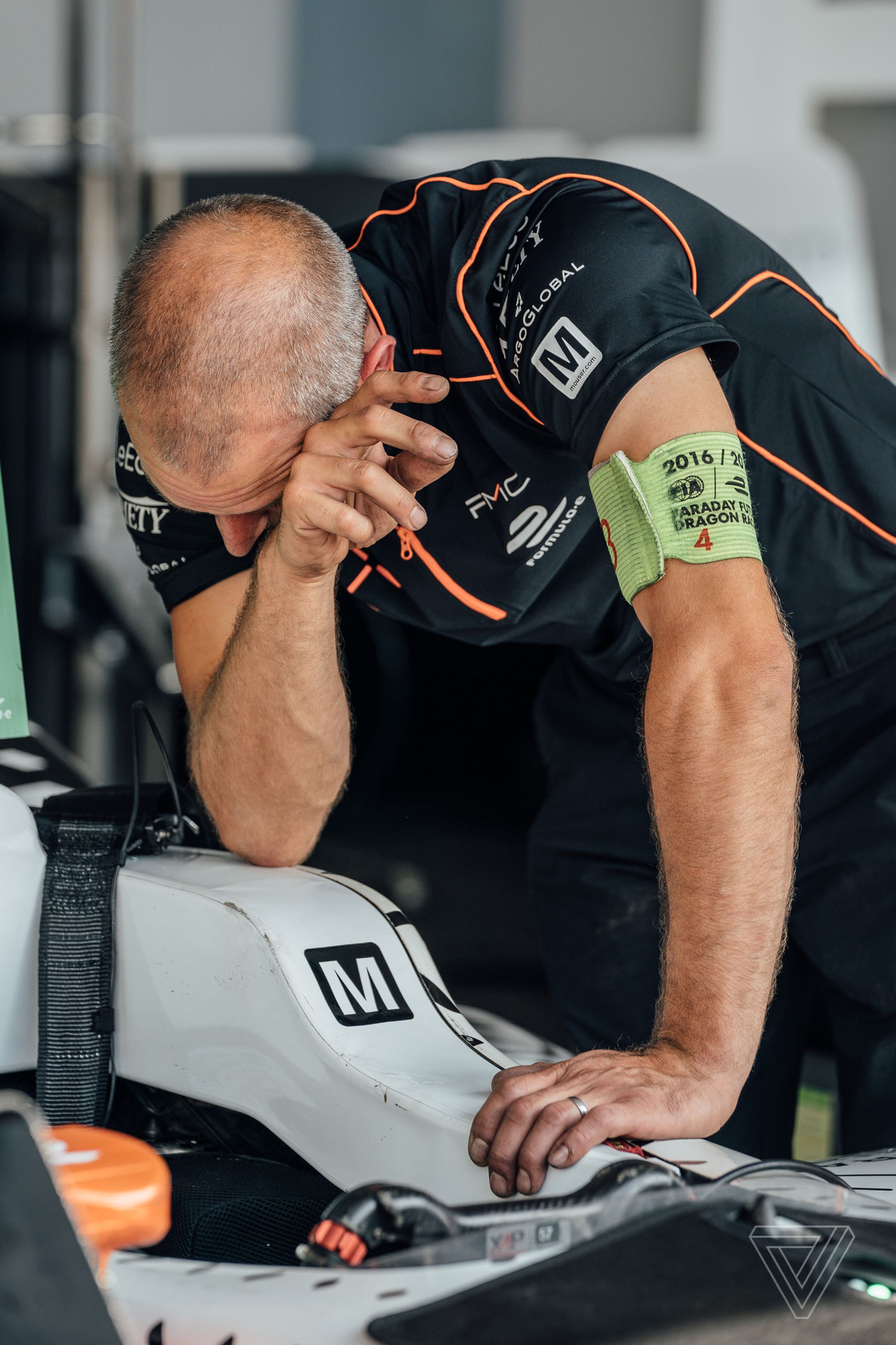 A member of the Faraday Future Dragon Racing team helps set up the cockpit for the driver.