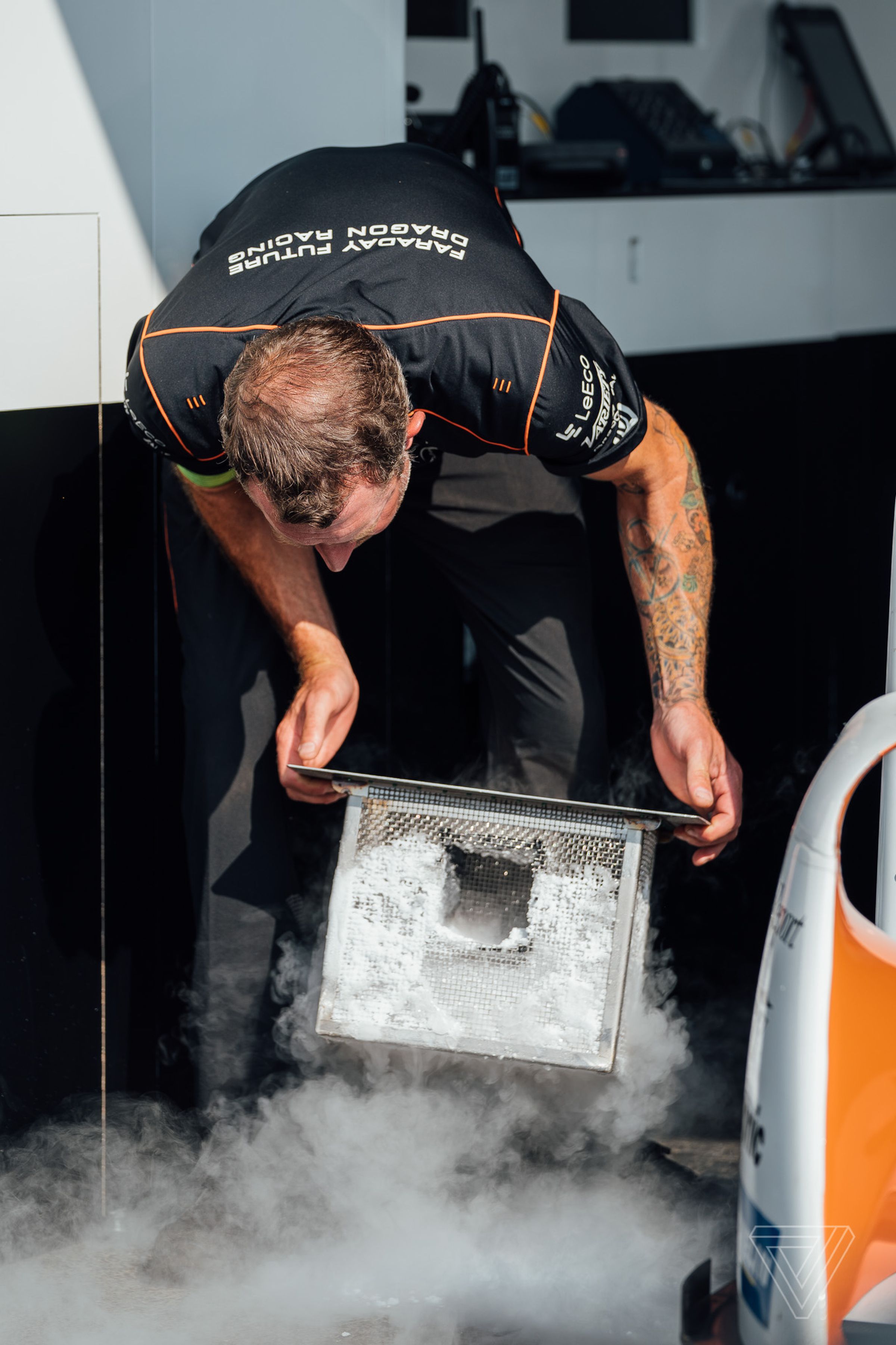 Another person from the Faraday Future Dragon Racing crew changes out the dry ice being used to keep the car’s battery cool.