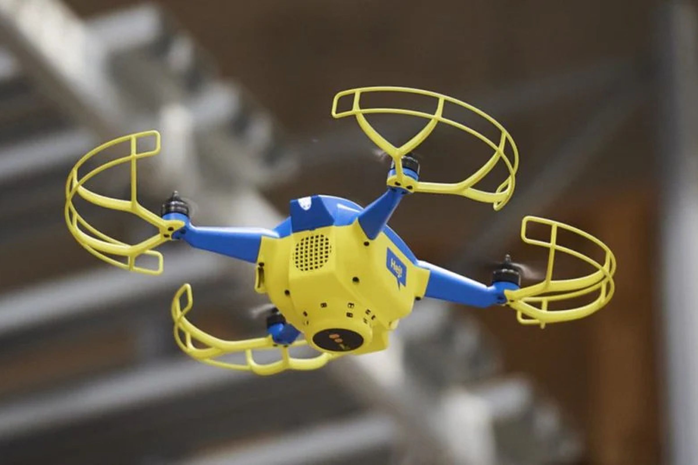 An image showing a blue and yellow drone in mid-air