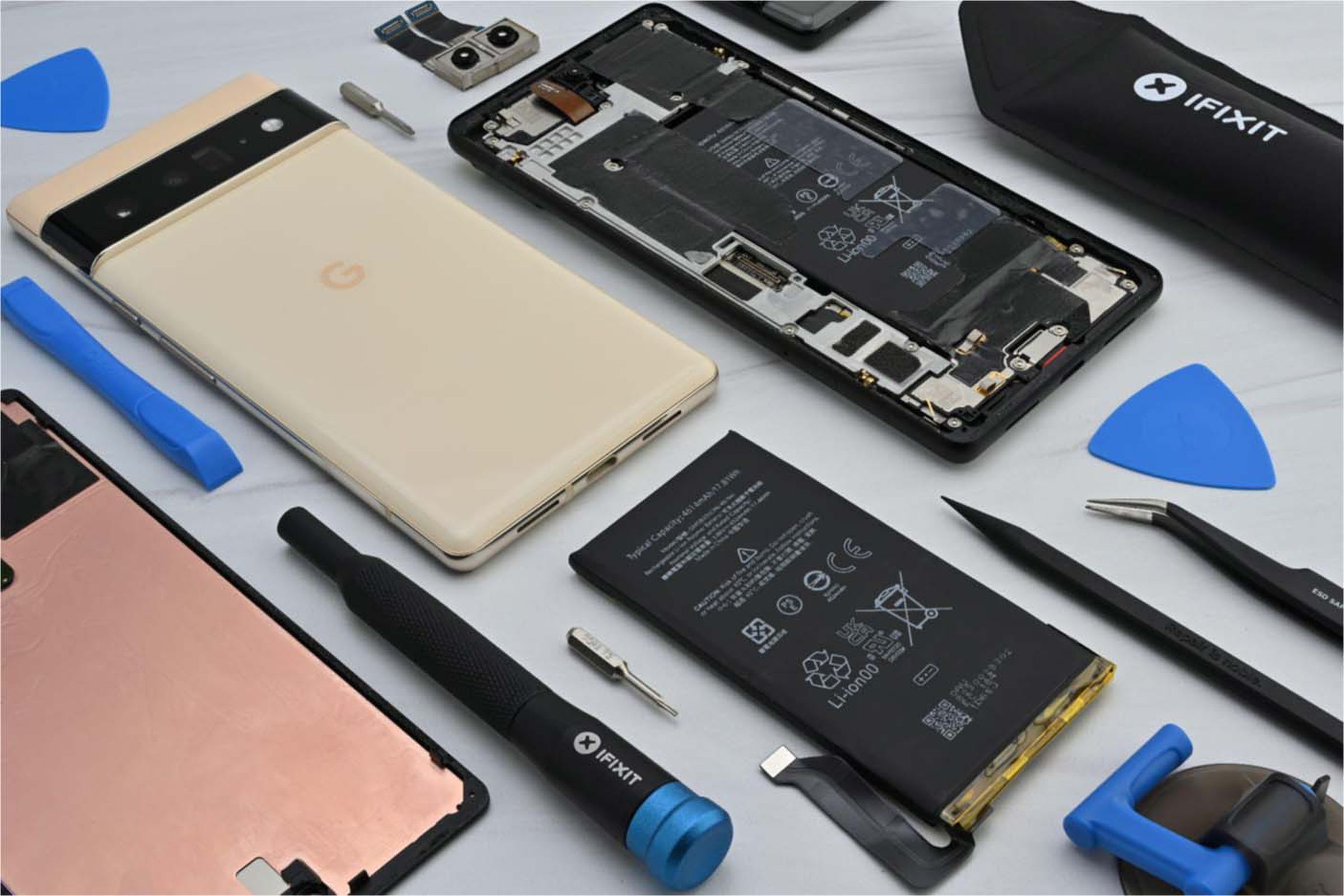 A Google Pixel smartphone surrounded by iFixit repair tools.