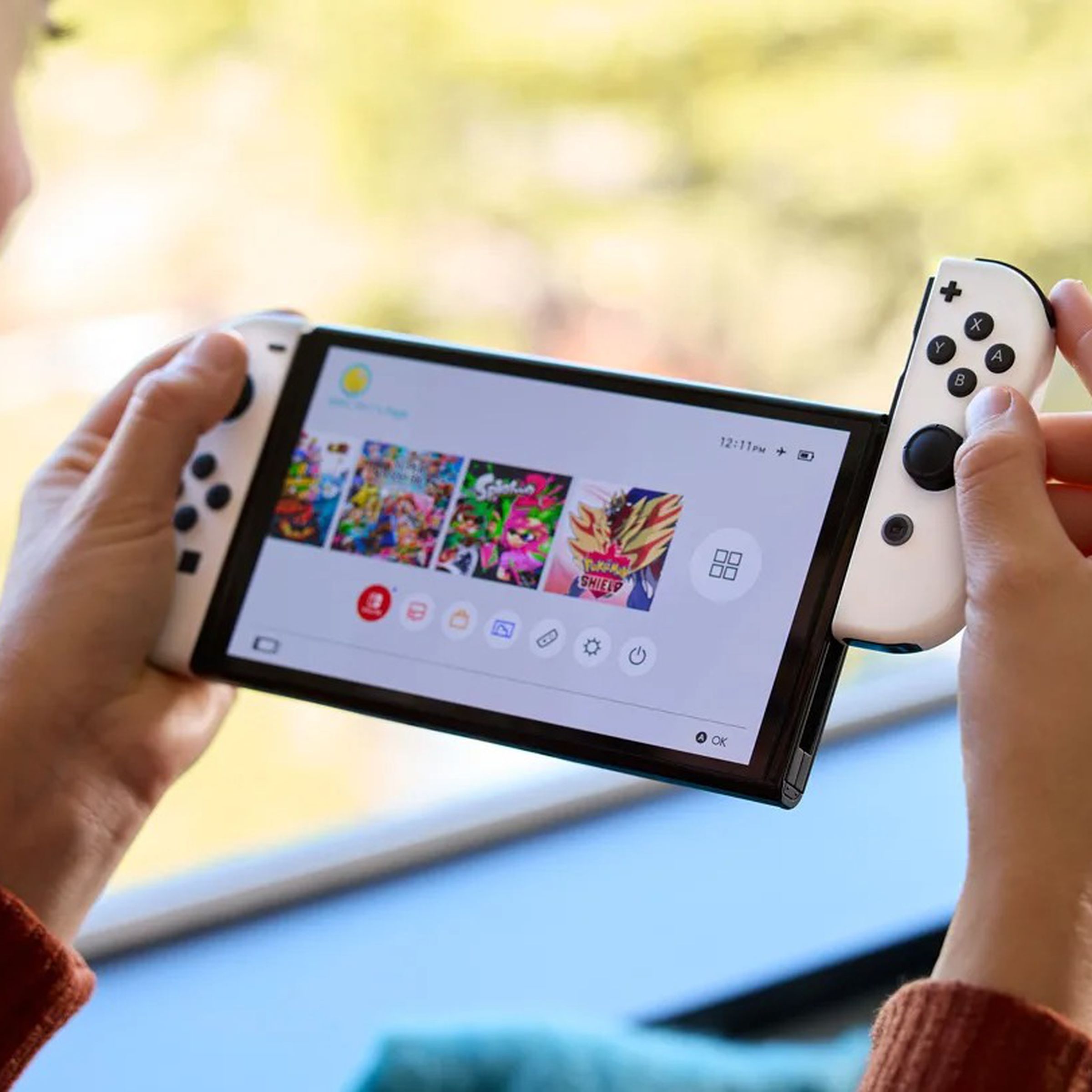 A close-up image of a woman sliding a Joy-Con controller off a white Nintendo Switch OLED.