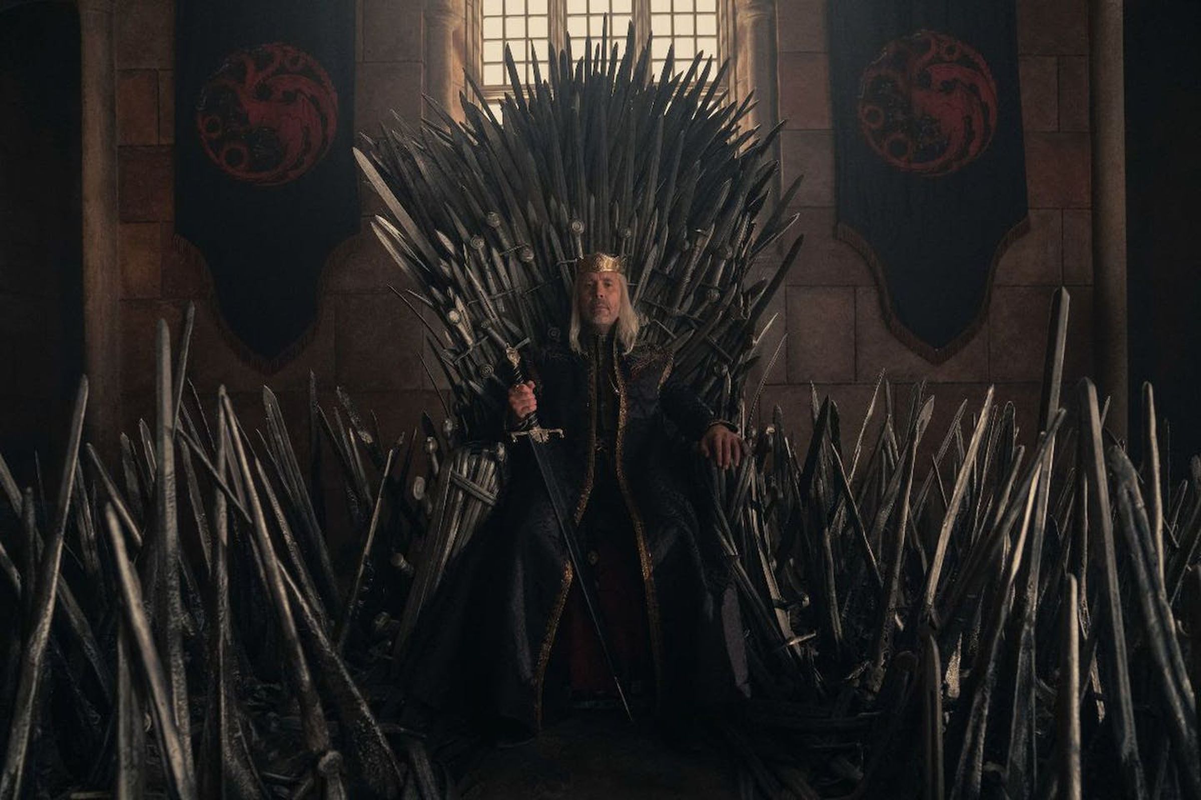 A character from the House of the Dragon sits on the Iron Throne.