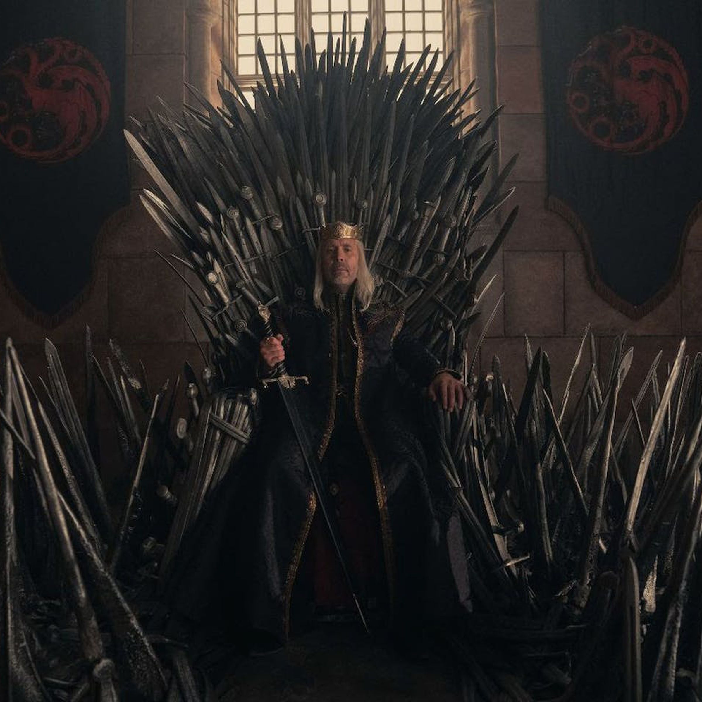 A character from the House of the Dragon sits on the Iron Throne.