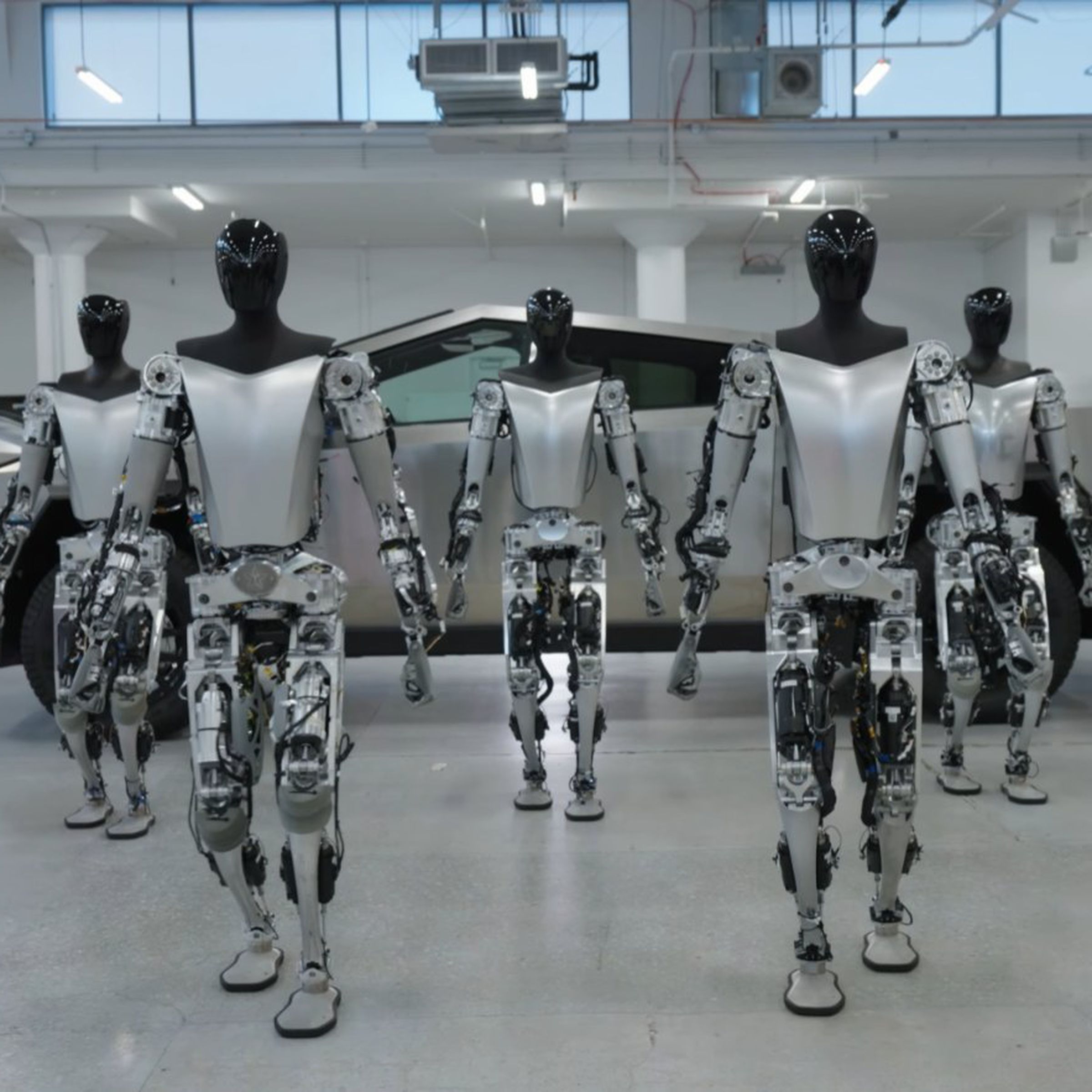 Tesla Bots shown walking in front of a Cybertruck