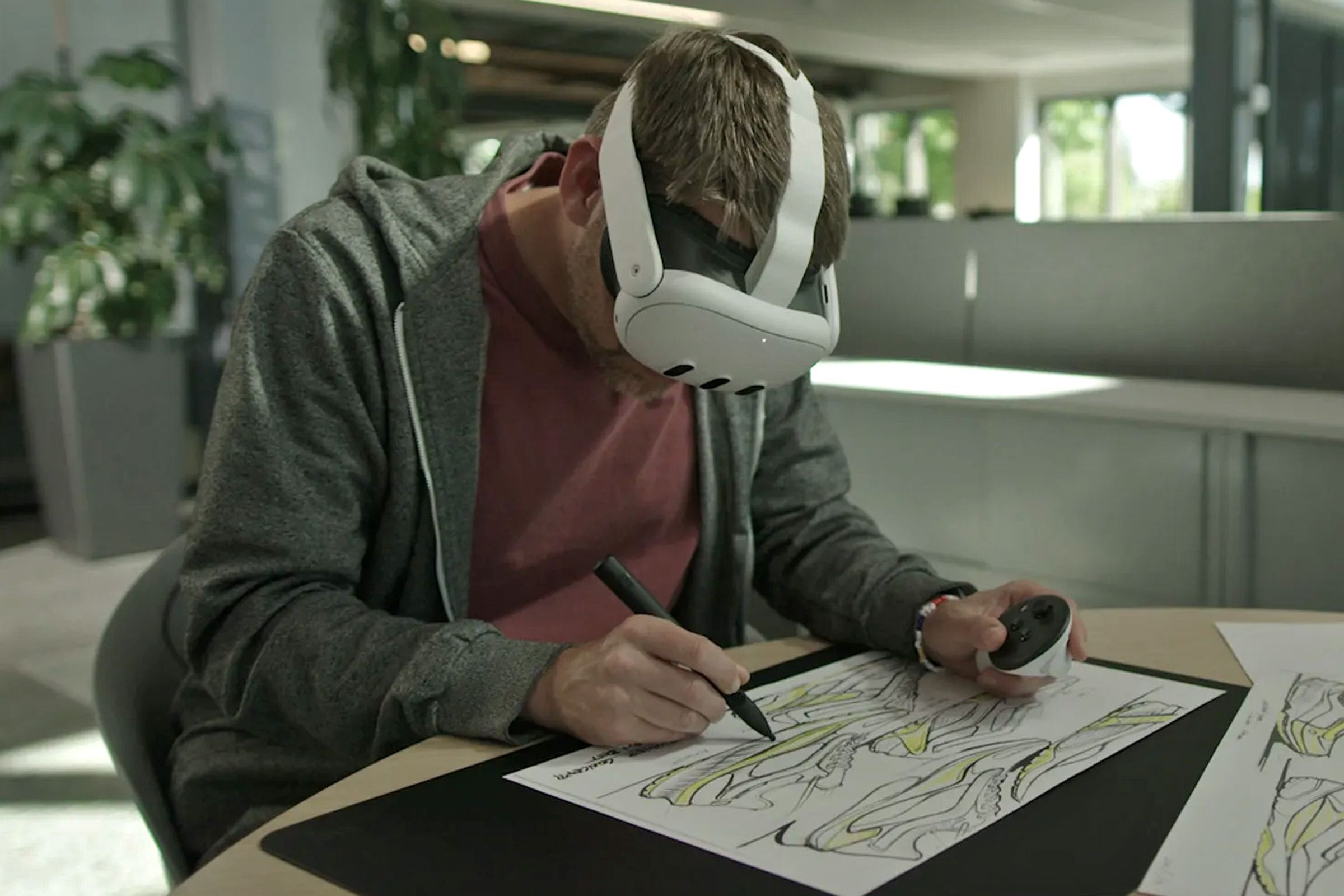 An artist wearing a Meta Quest 3 headset traces an image using the Logitech MX Ink stylus.