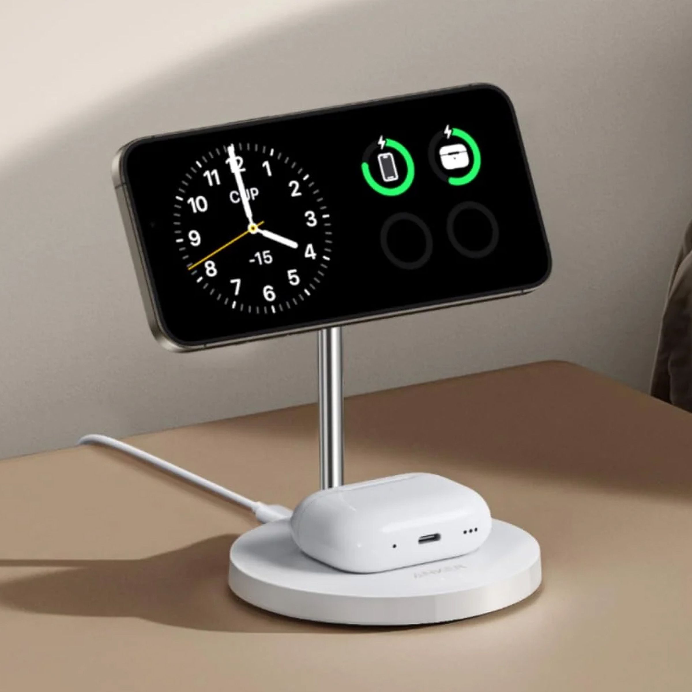 A tilted close-up image of Anker’s white MagGo Wireless Charger with a pair of AirPods on the bottom and an iPhone showing StandBy mode on the top.