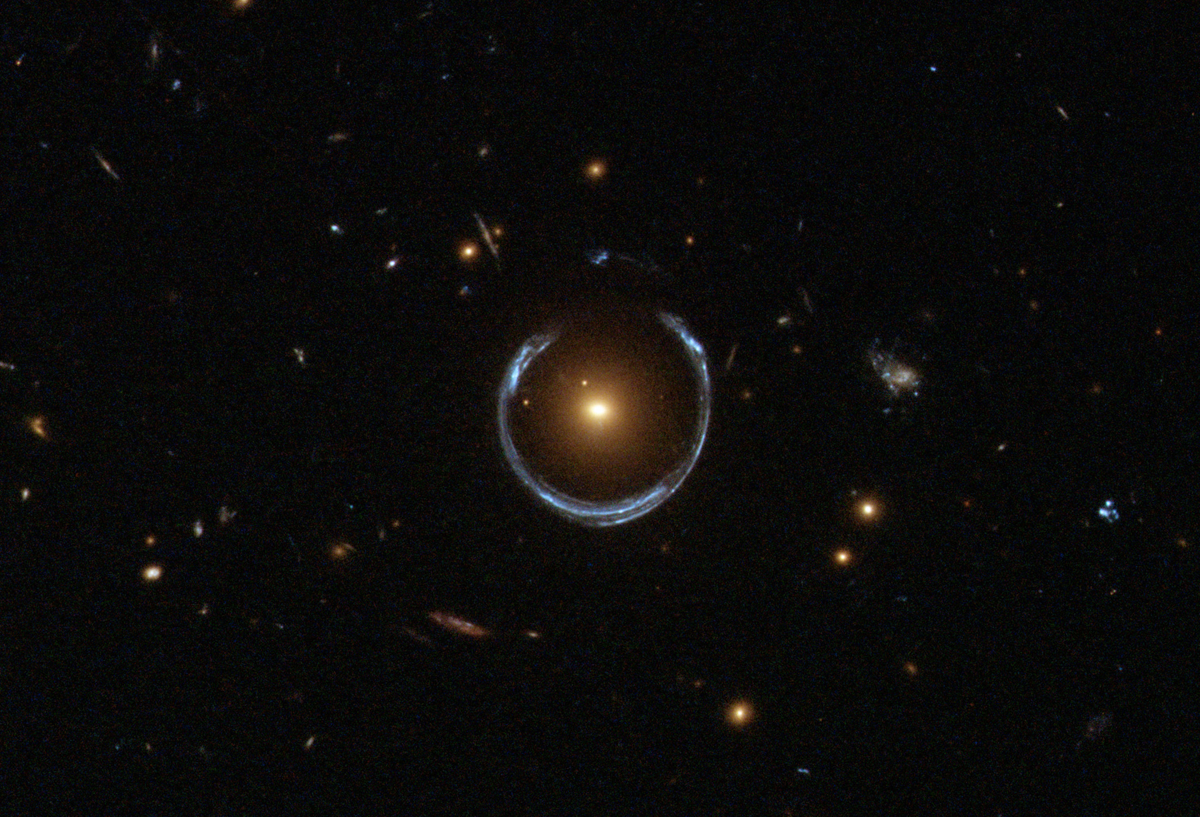 A gravitational lens. The nearer red galaxy has bent the light of the more distant blue galaxy around it in a horseshoe shape.