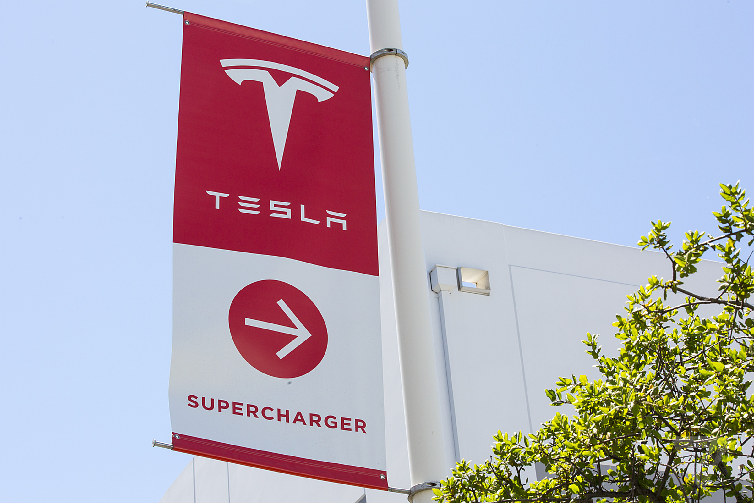 pole flag pointing towards Tesla charging stations