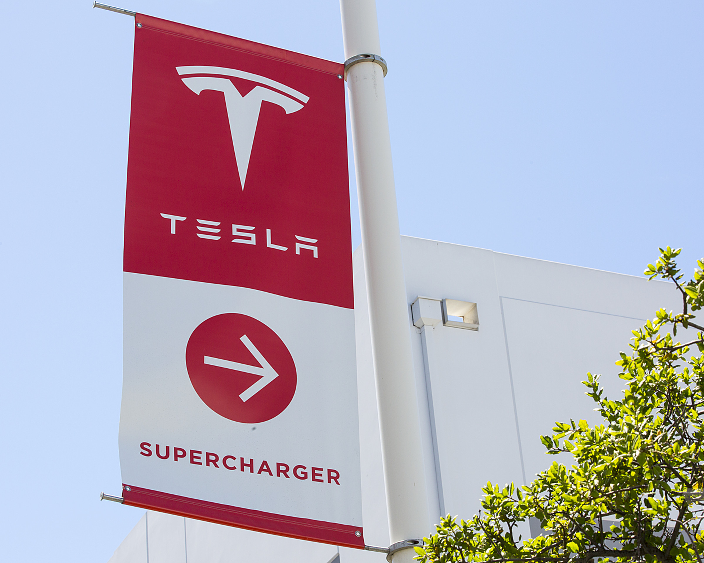 pole flag pointing towards Tesla charging stations
