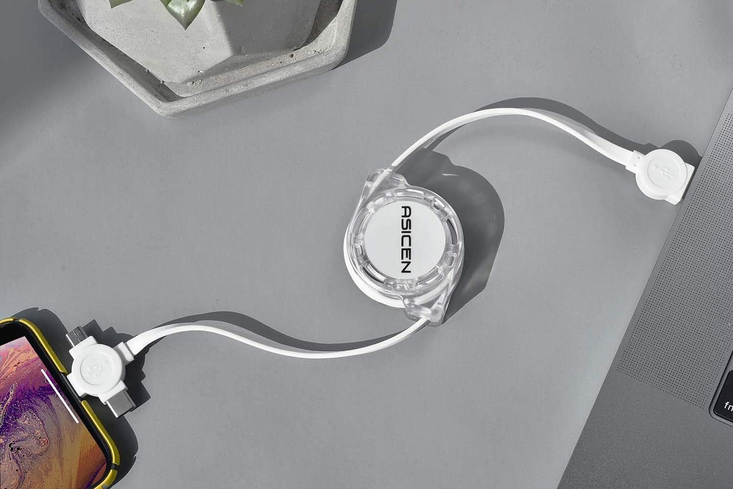The Asicen retractable 3-in-1 charging cable plugged into a phone and laptop.