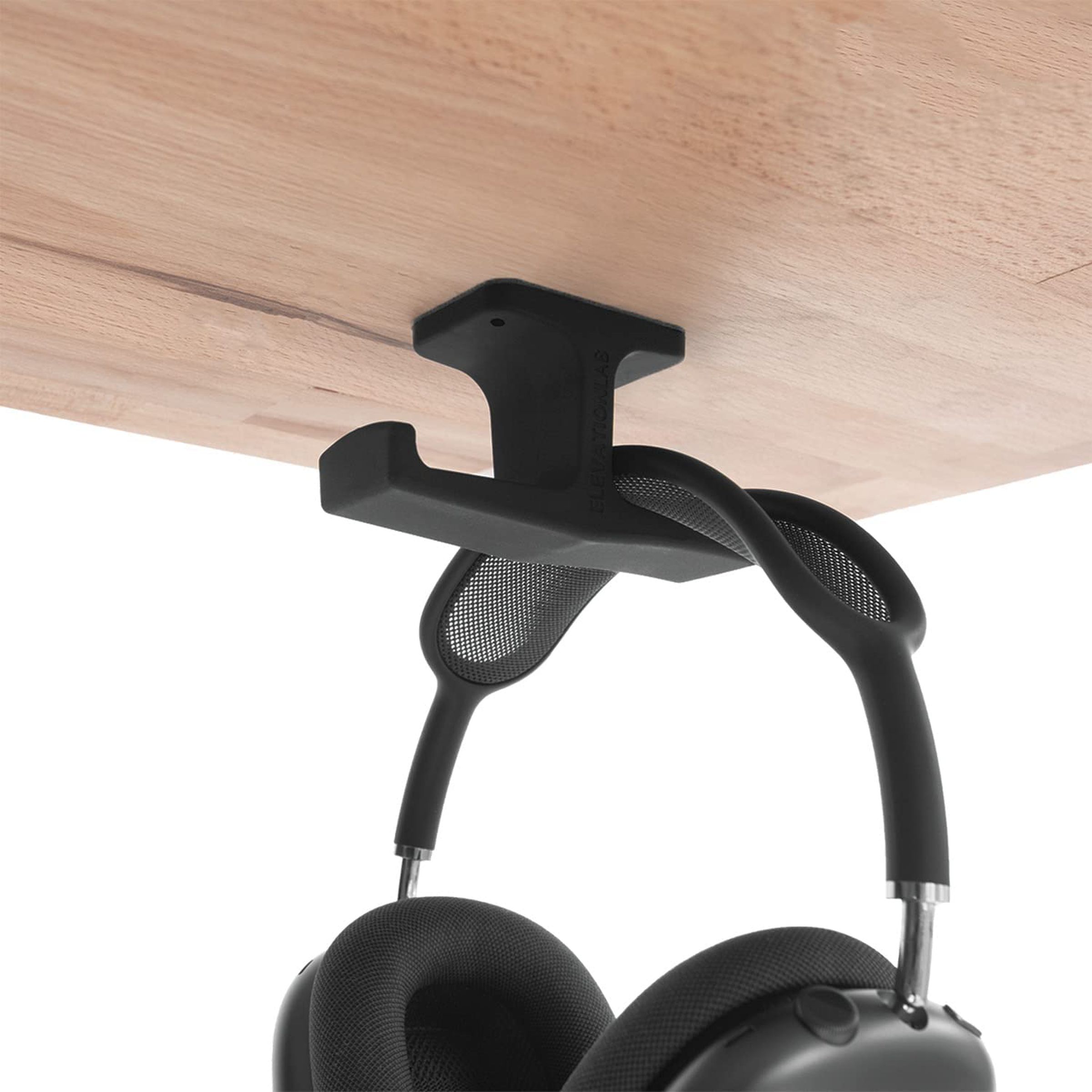 A double-hook fastened under a desk that holds a pair of headphones.