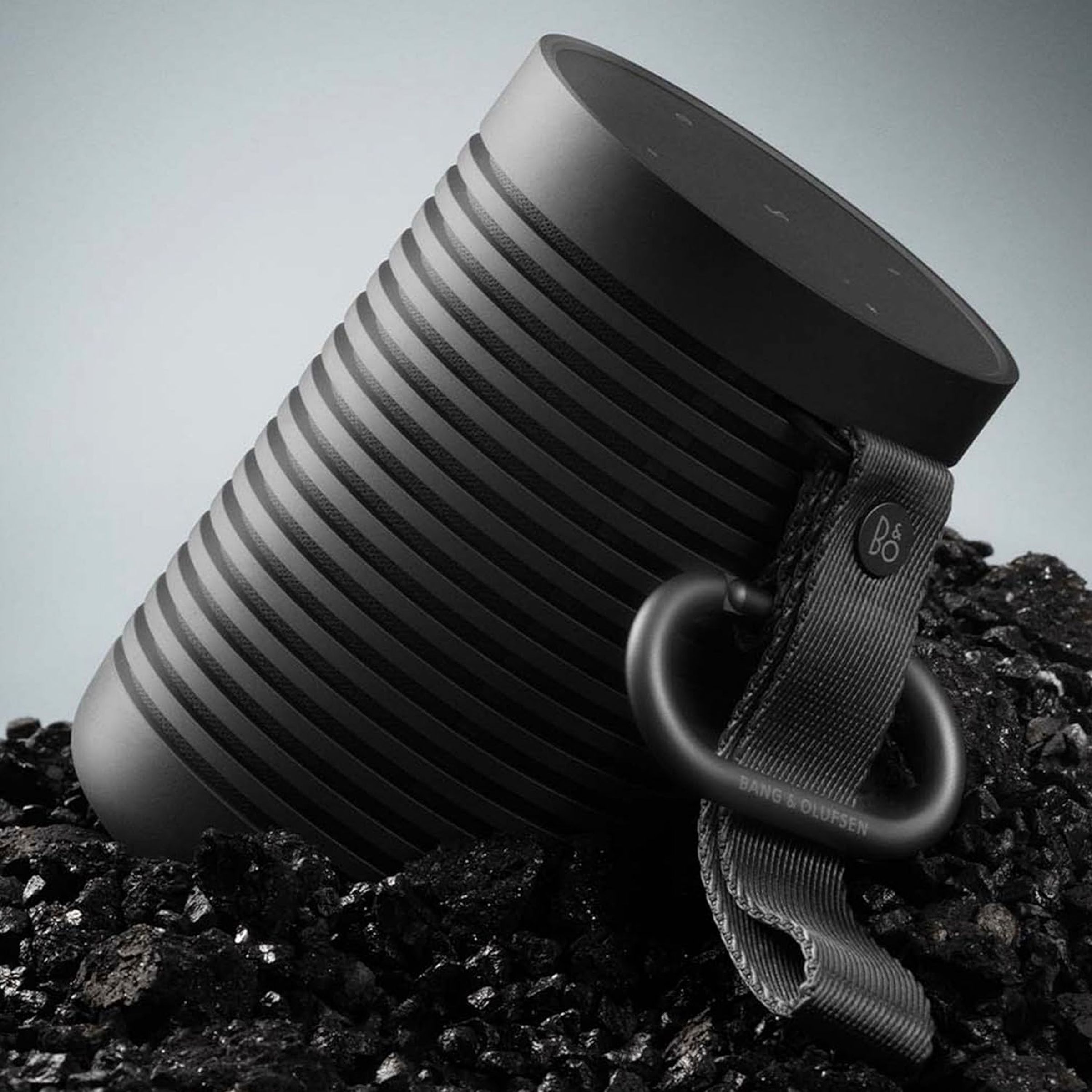 Bang and Olufson Beound Explore portable speaker leaning against rocks