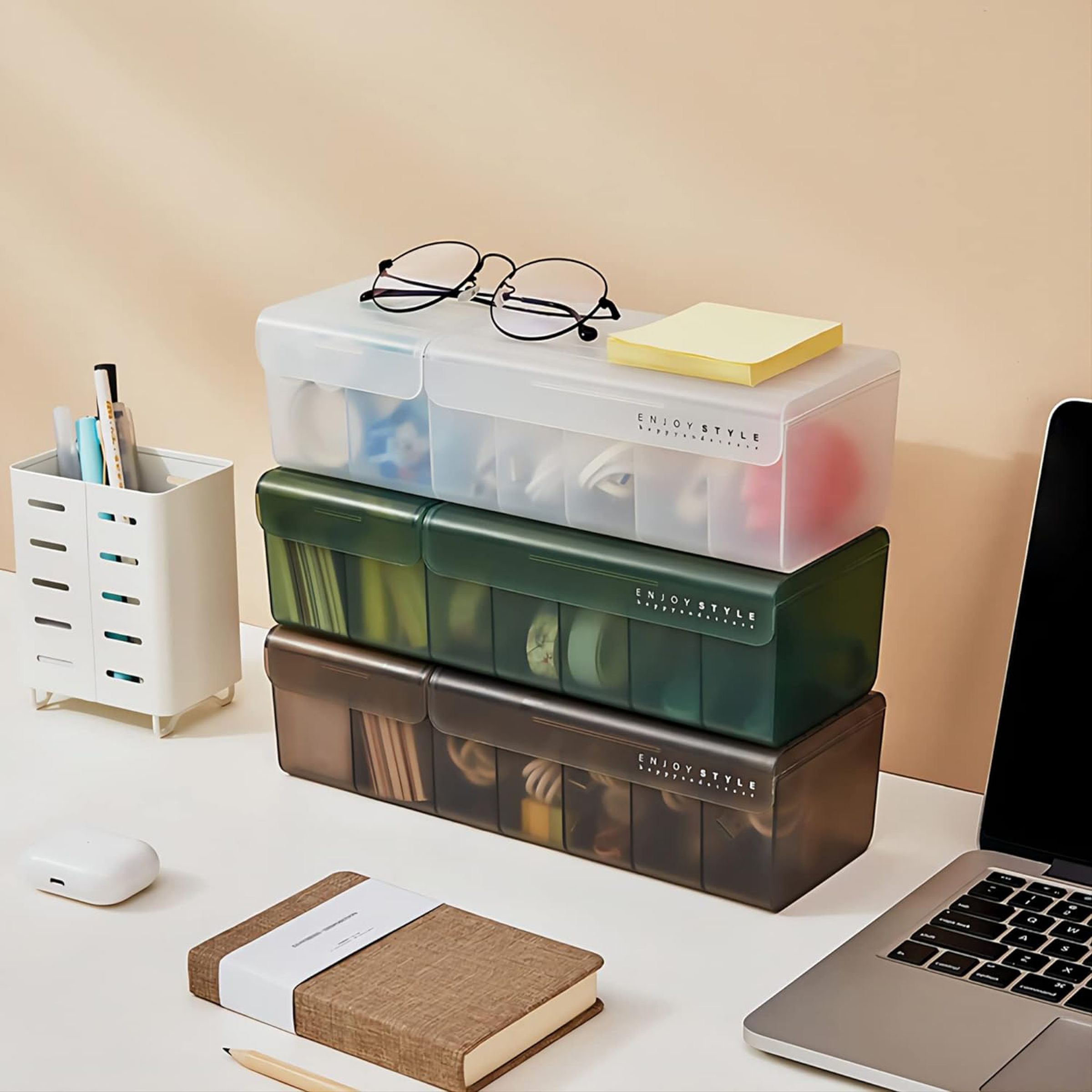 Three storage boxes piled on a desk.