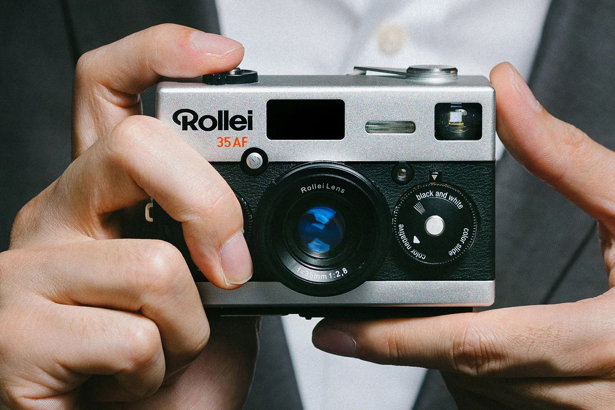 A person holding a small film camera, the Rollei 35AF.