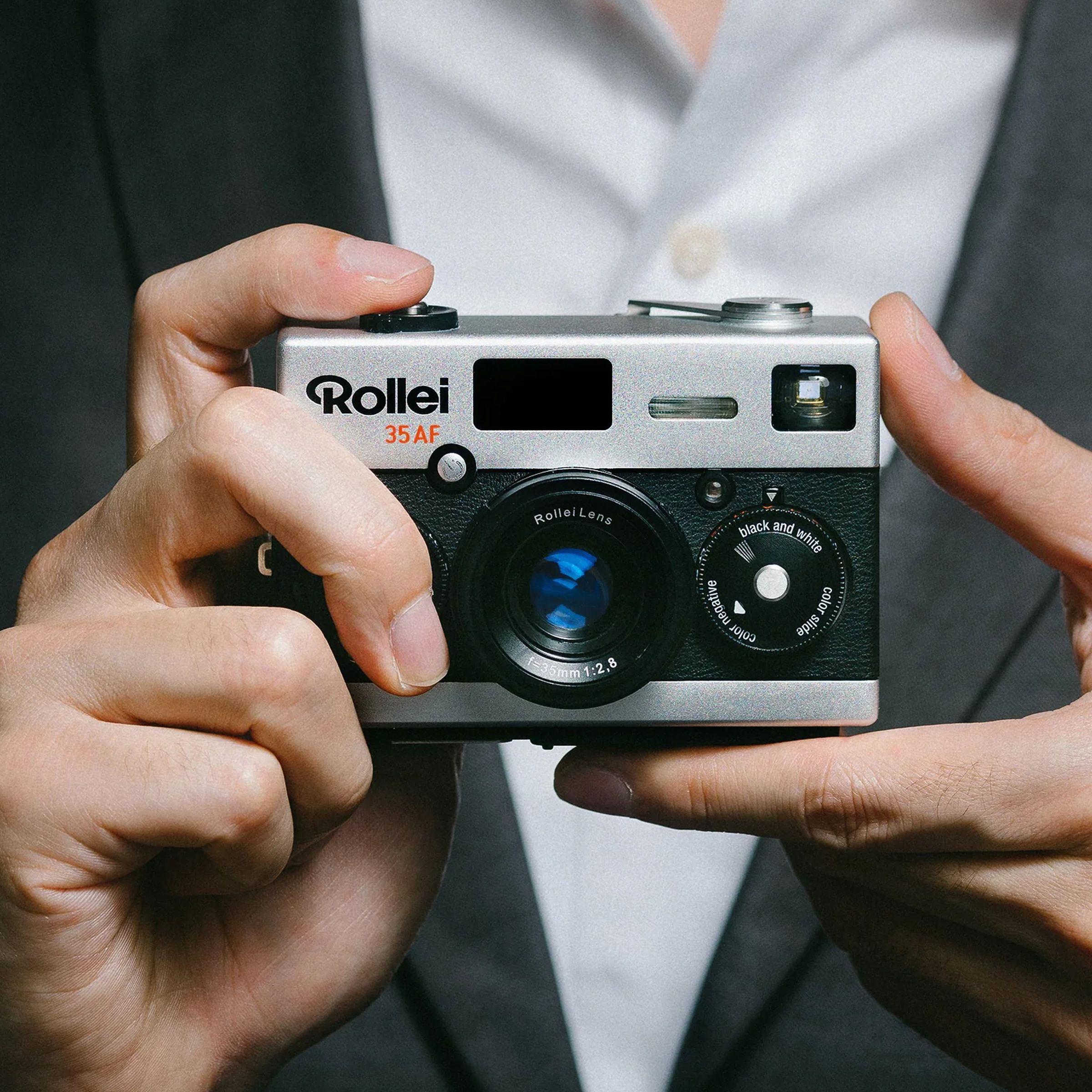 A person holding a small film camera, the Rollei 35AF.