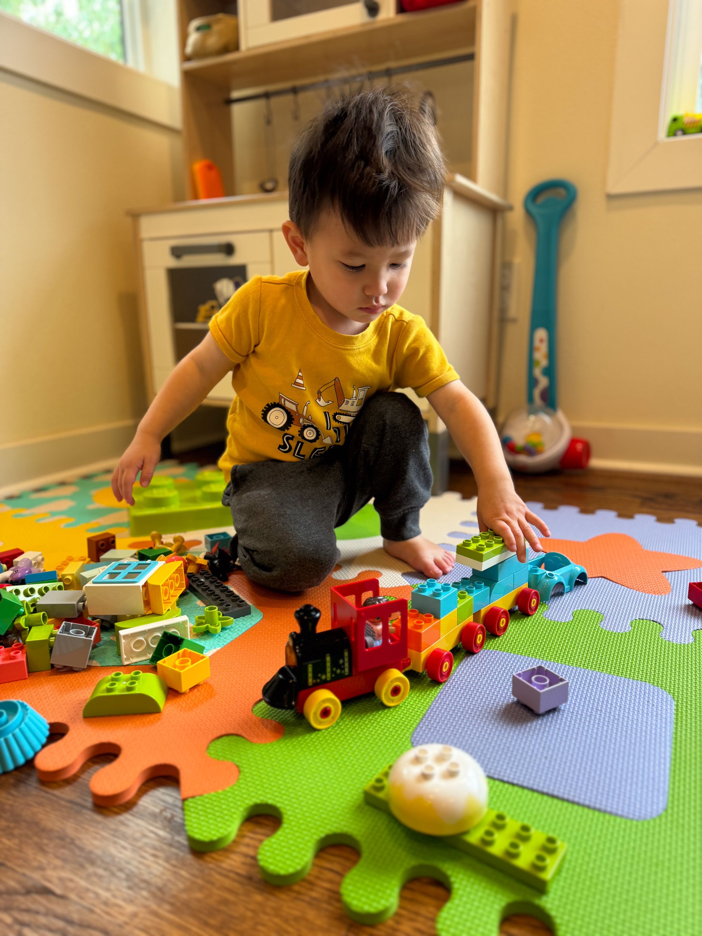 Photo of a child playing with toy Lego train