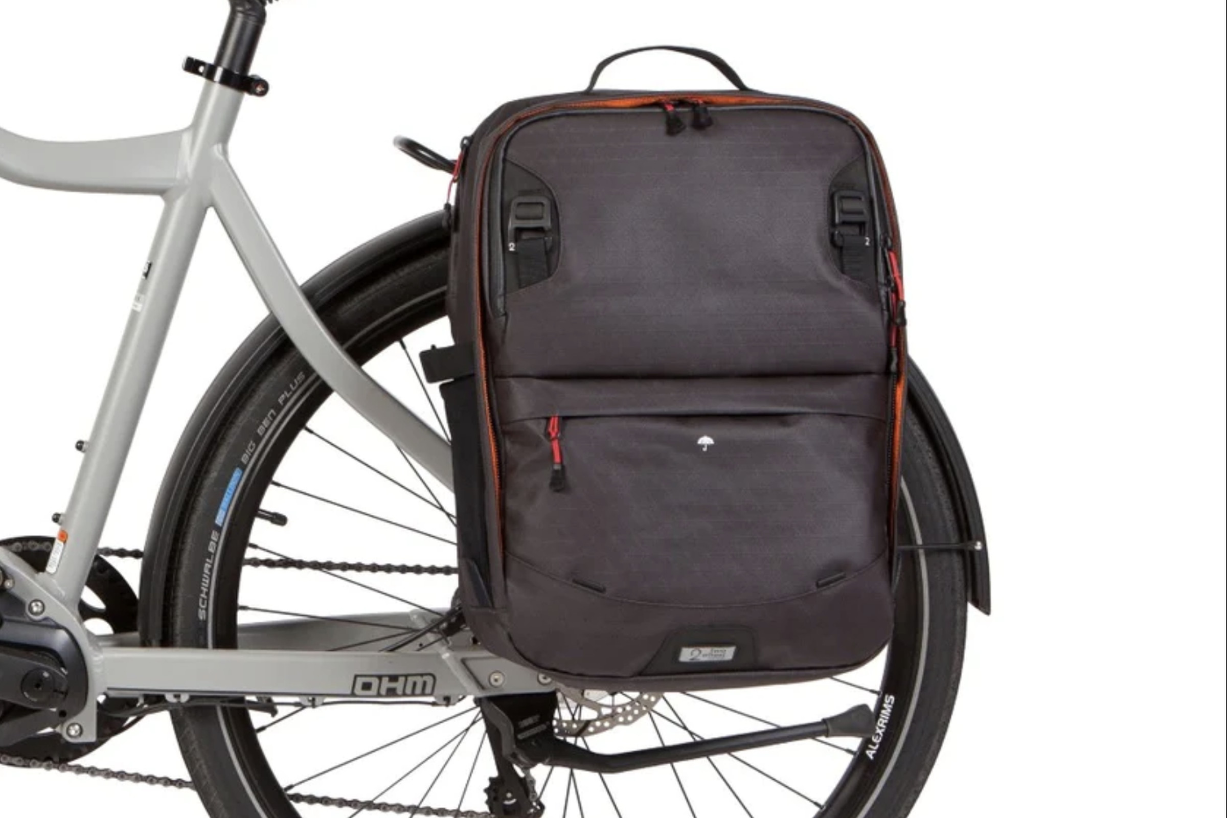 The back end of a bicycle with a backpack attached above the rear wheel.