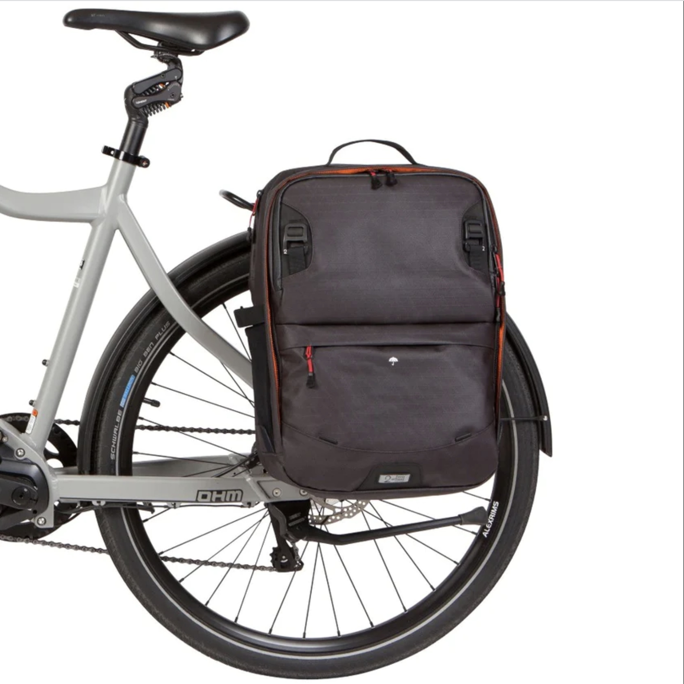 The back end of a bicycle with a backpack attached above the rear wheel.