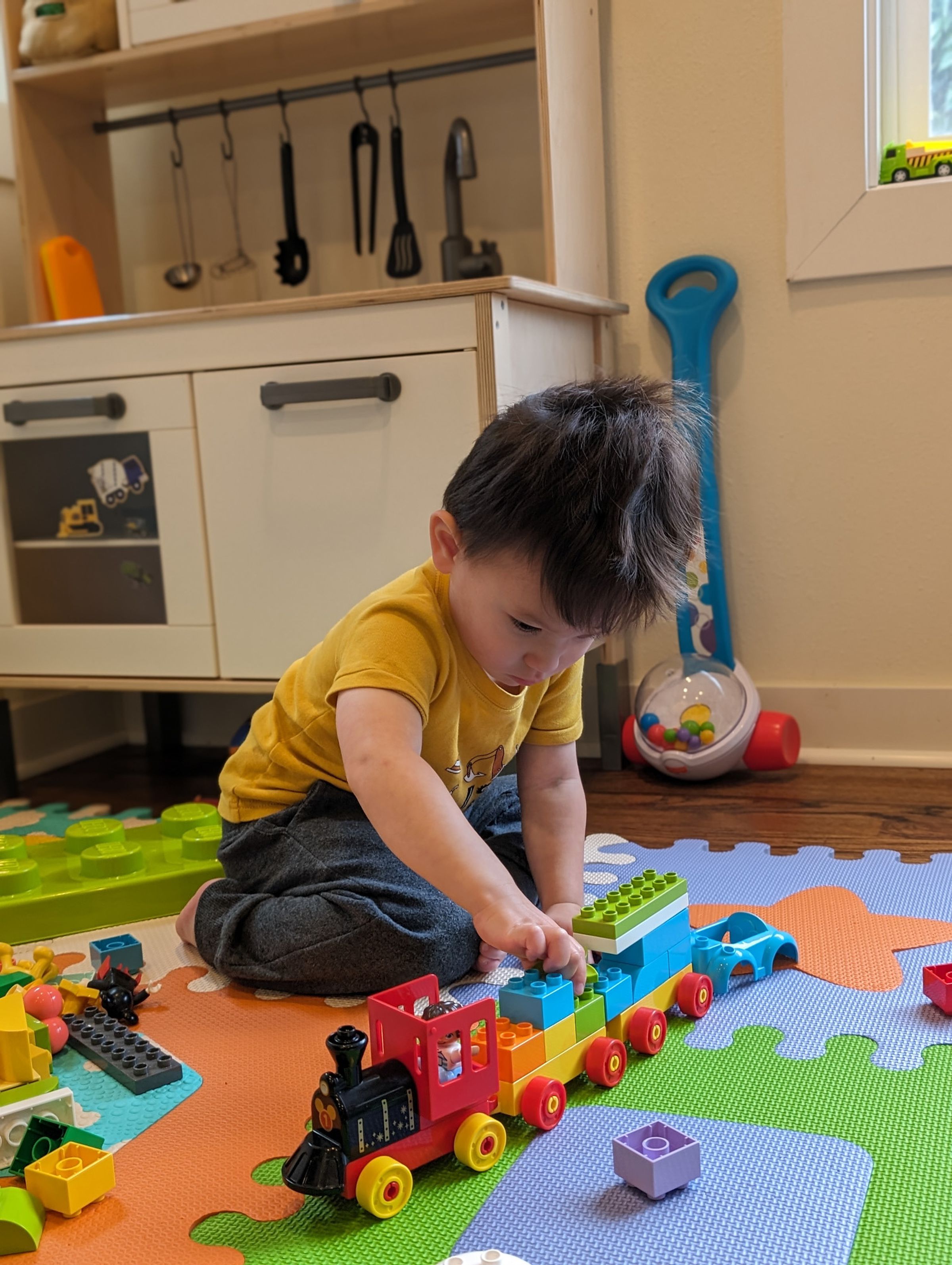 Photo of a toddler playing with Lego toy train