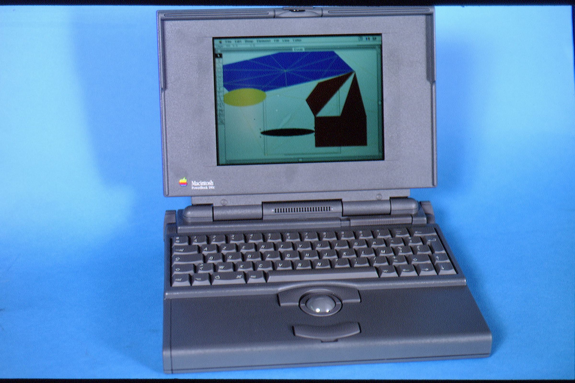 An Apple Powerbook sitting against a blue background.