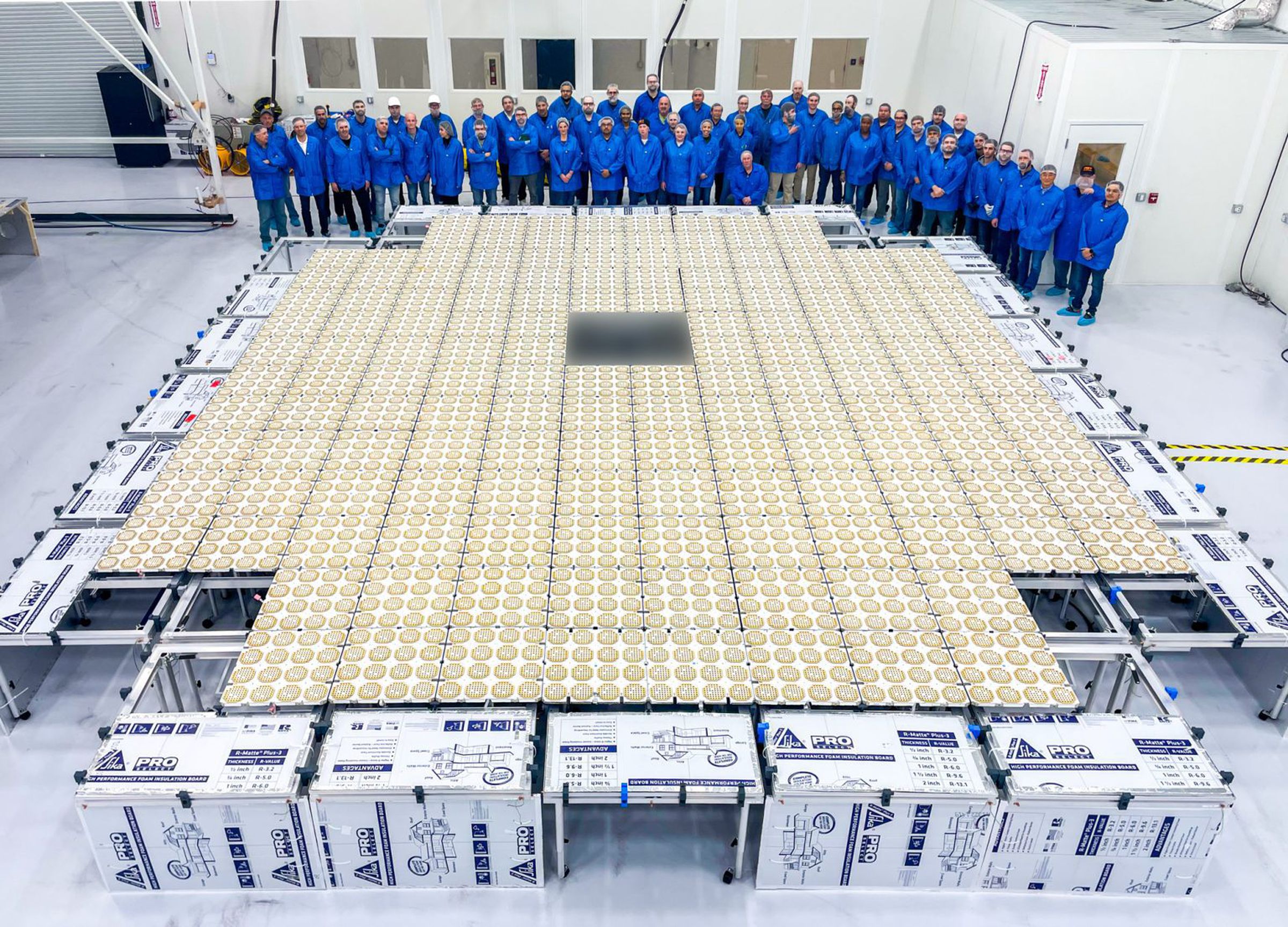 The BlueWalker 3 satellite was placed on a warehouse floor, surrounded by technicians wearing blue overalls.