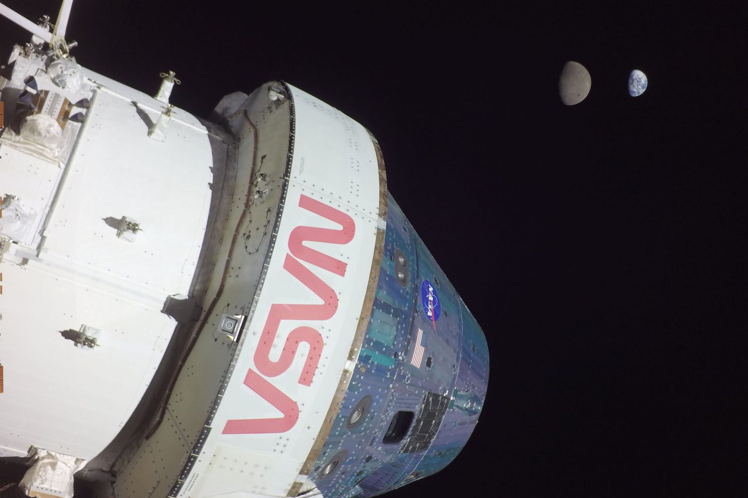 The exterior of the Orion capsule, with the Moon and Earth in the distance.