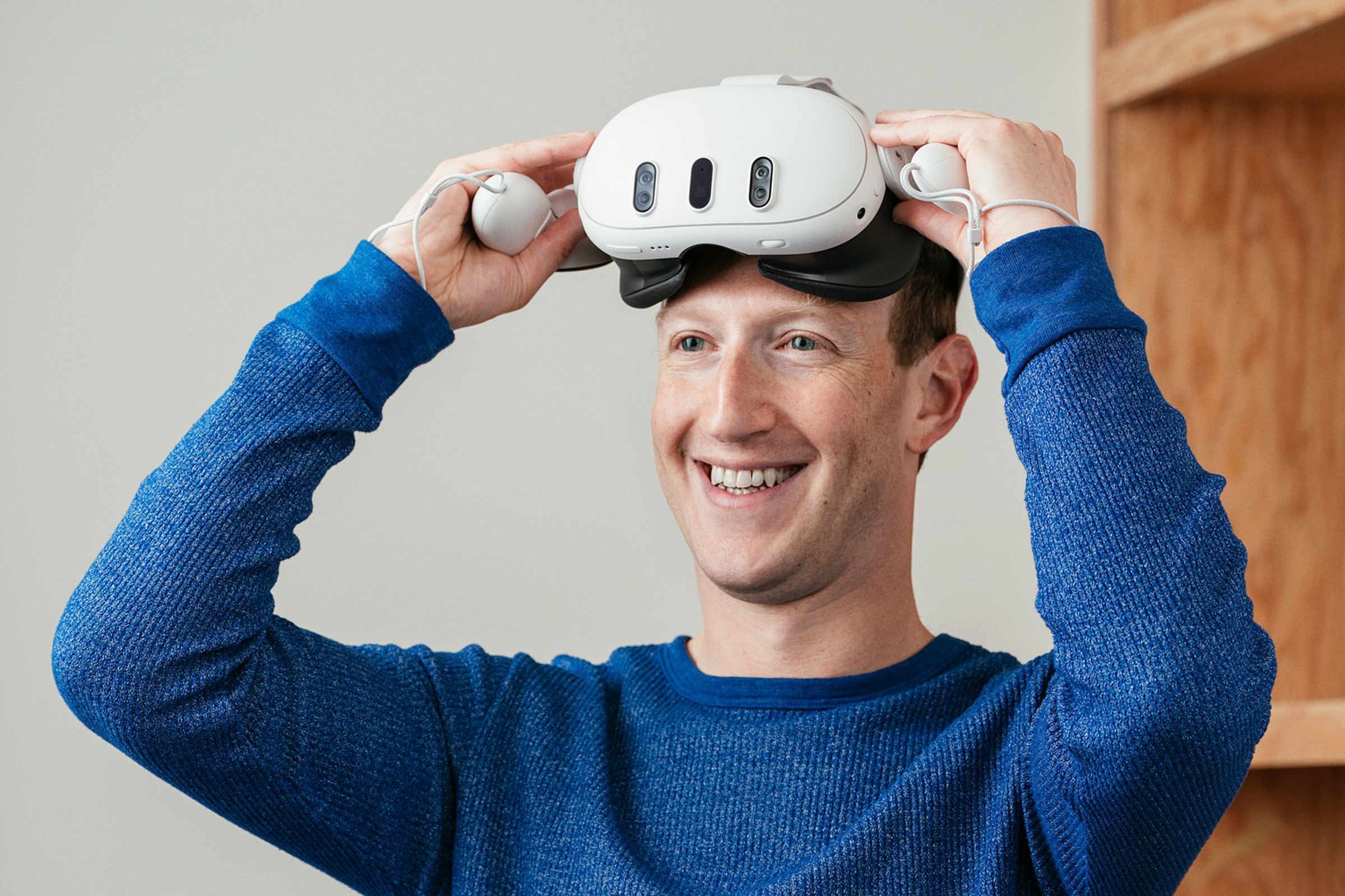 Mark Zuckerberg wearing the Meta Quest 3 headset and smiling.