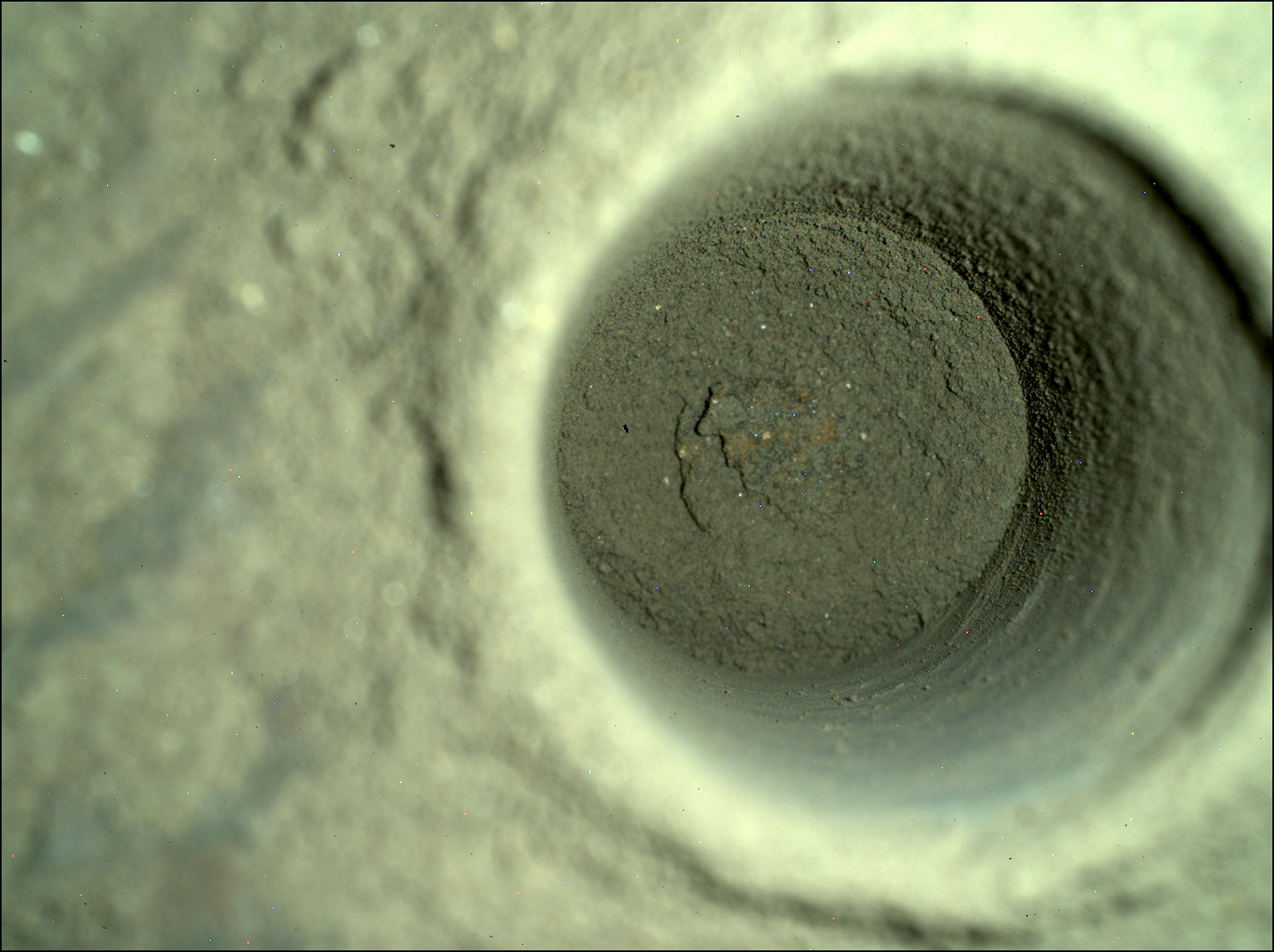 A closeup of the hole left by Perseverance, captured by the rover’s SHERLOC WATSON camera.