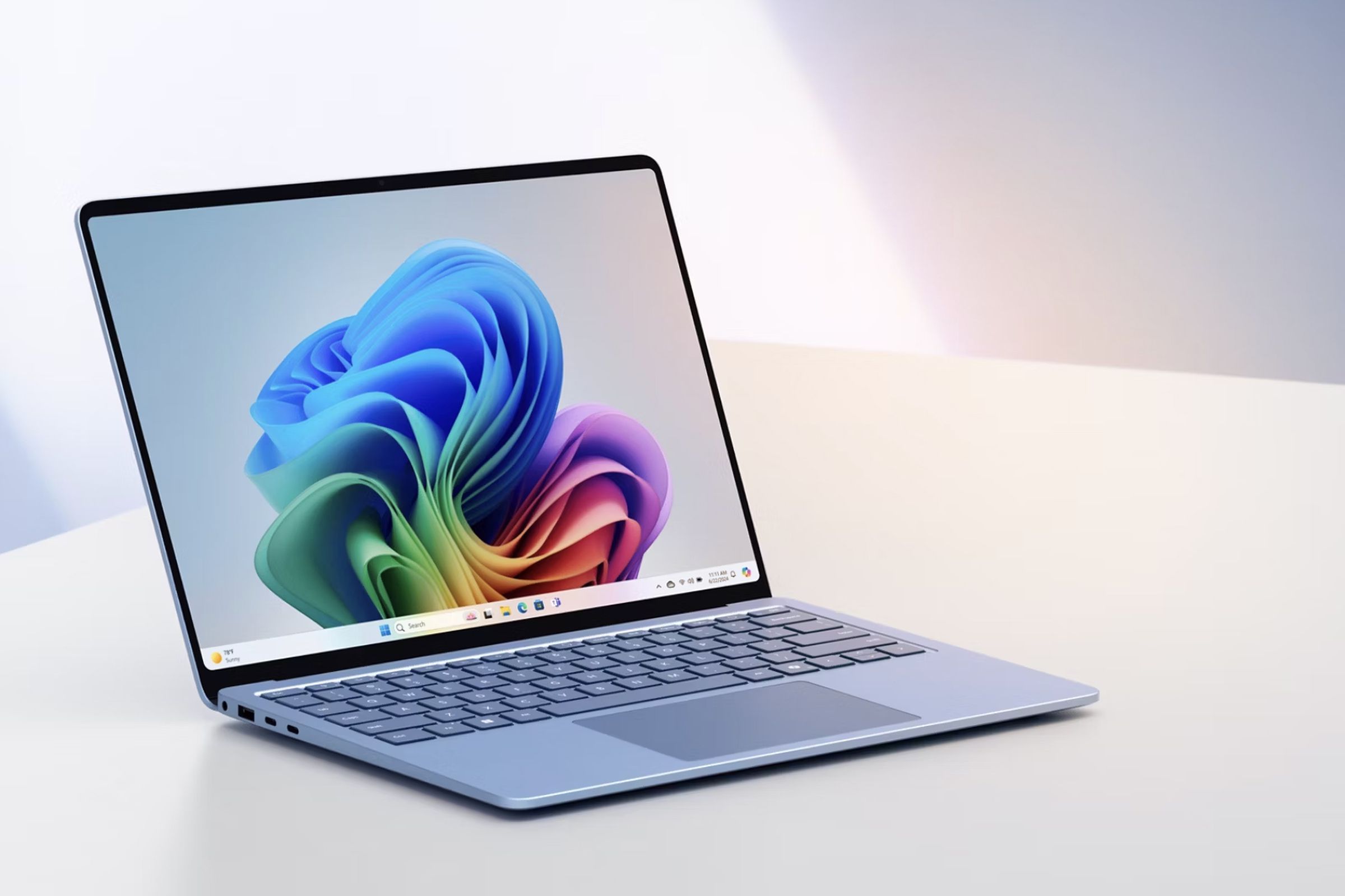 The sapphire version of Microsoft’s 2024 Surface Laptop sitting angled on a white countertop.