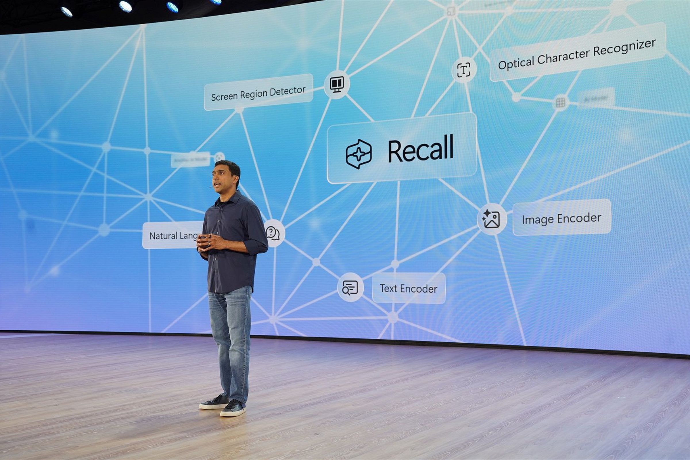 stage with recall logo on big screen, Microsoft VP for Windows and Devices Pavan Davuluri on stage