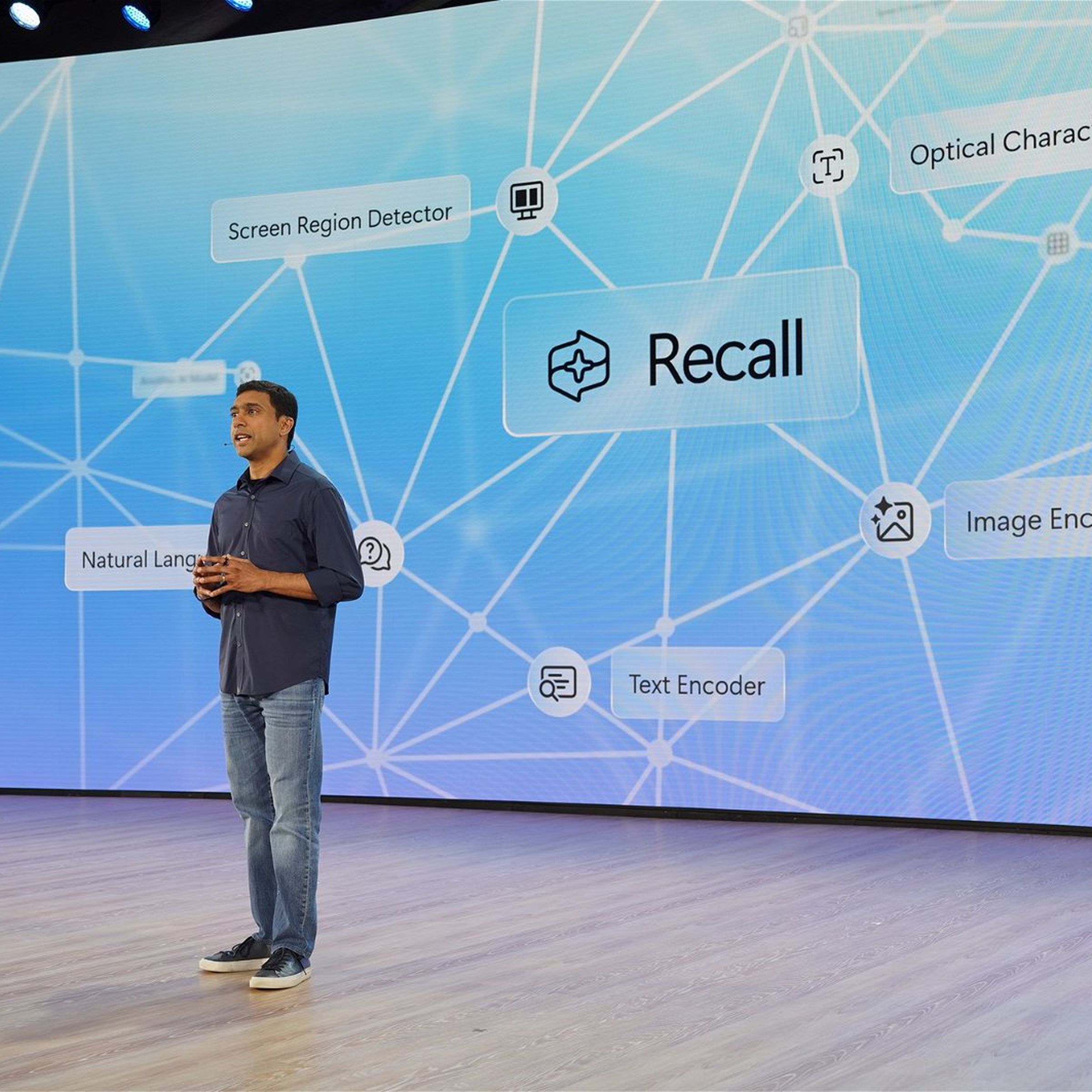 stage with recall logo on big screen, Microsoft VP for Windows and Devices Pavan Davuluri on stage