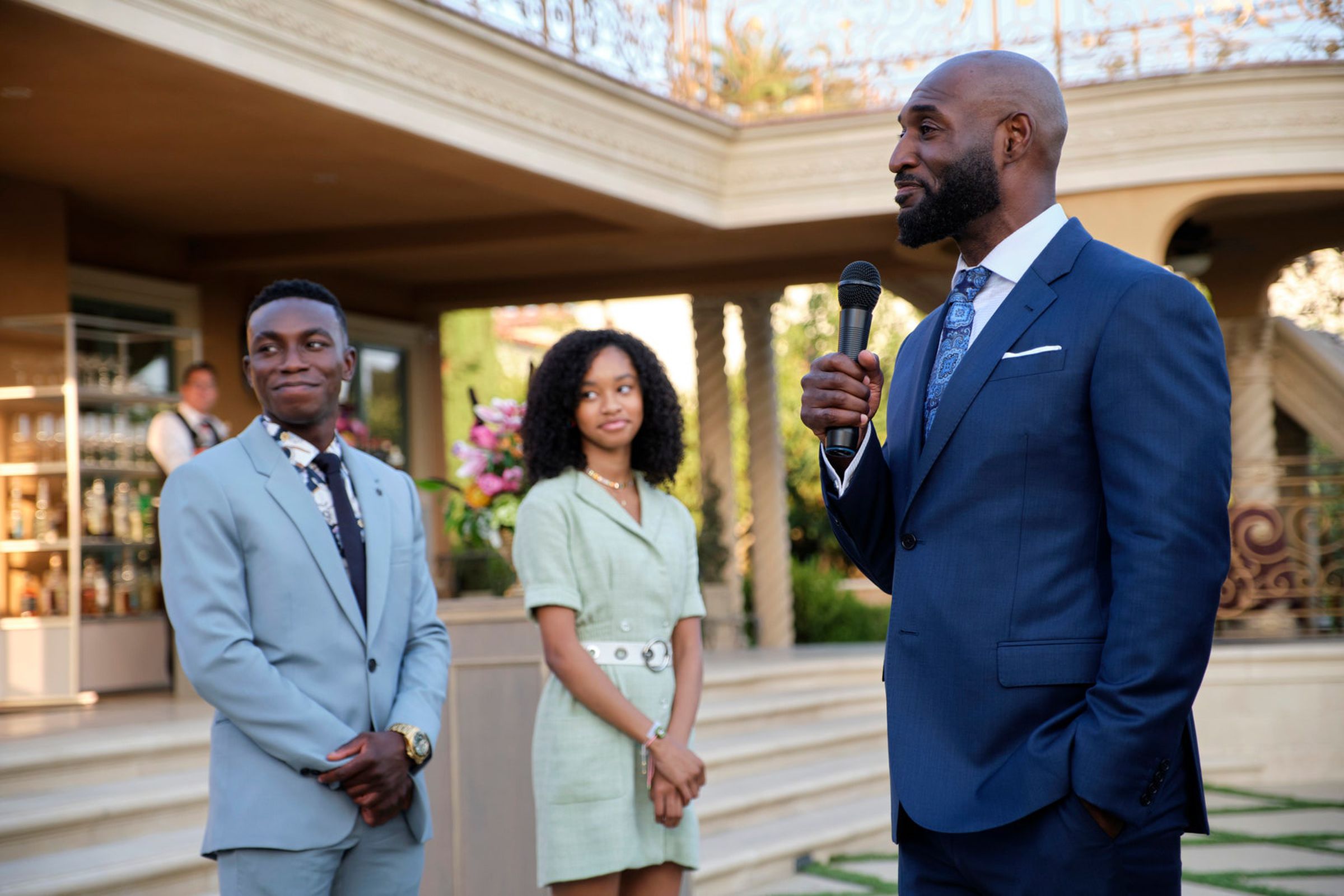 Phil Banks speaking at at an event alongside his children.