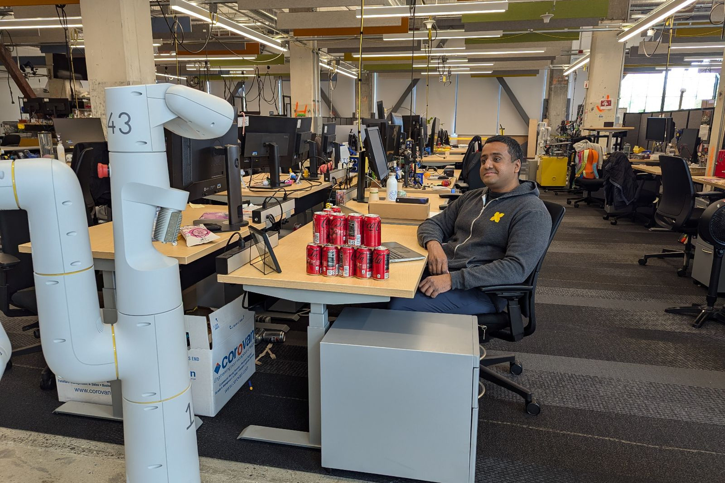 A Google DeepMind worker training a robot to understand that Coke is his favorite soda.