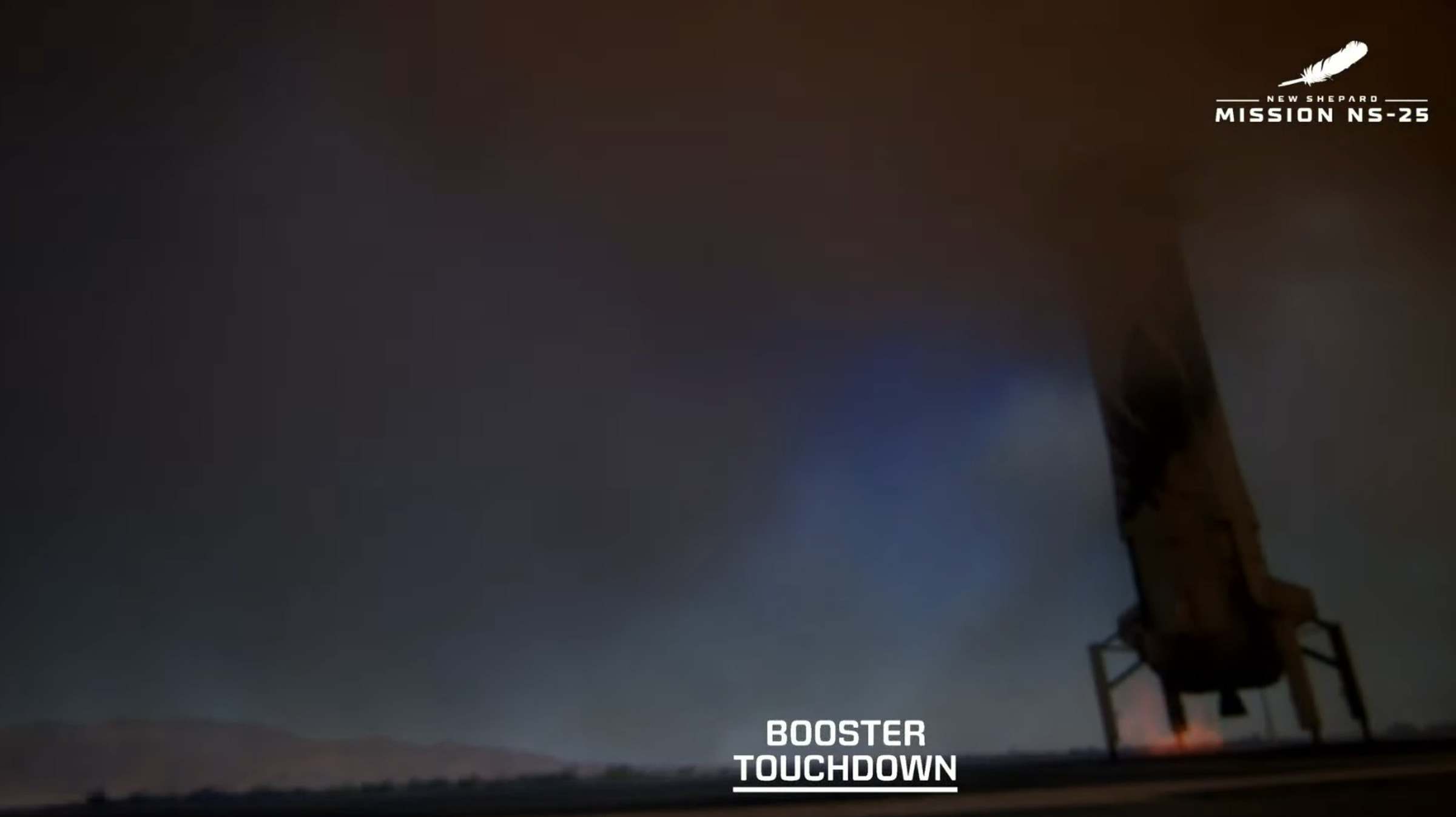 A screenshot showing the Blue Origin booster after setting down, silhouetted in a cloud of dust.