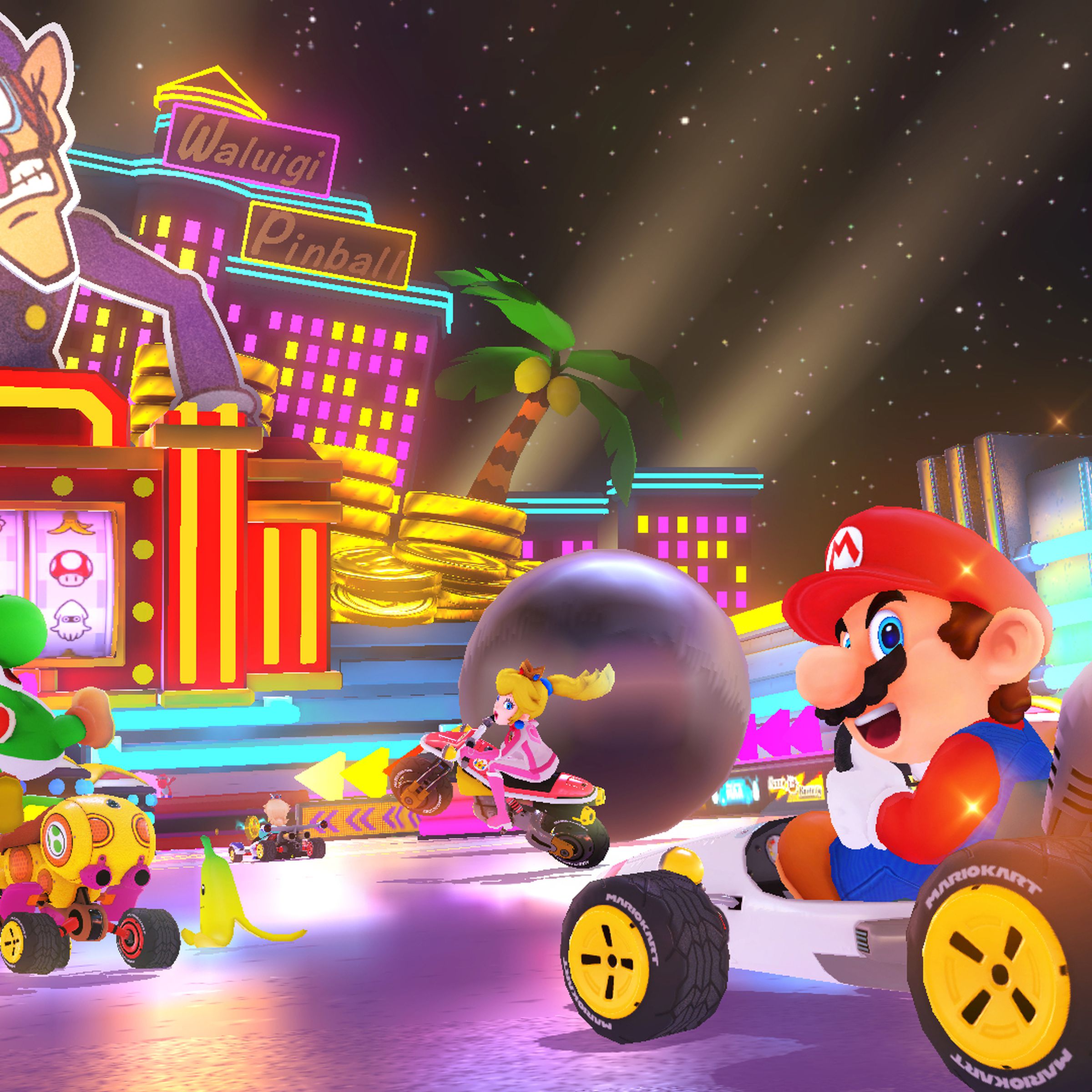 An image of Mario, Yoshi, and other Mario Kart characters driving on a course that resembles a pinball machine.