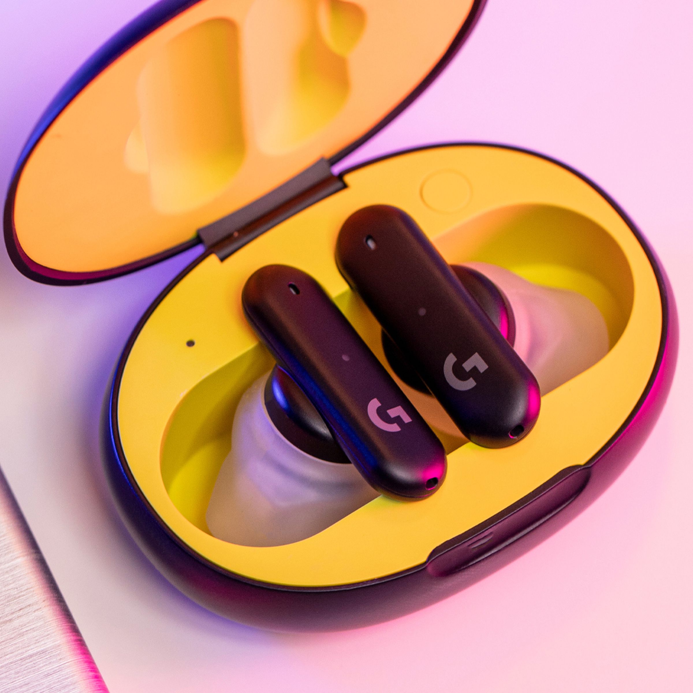 The Logitech G Fits wireless earbuds sitting in an opened yellow case.