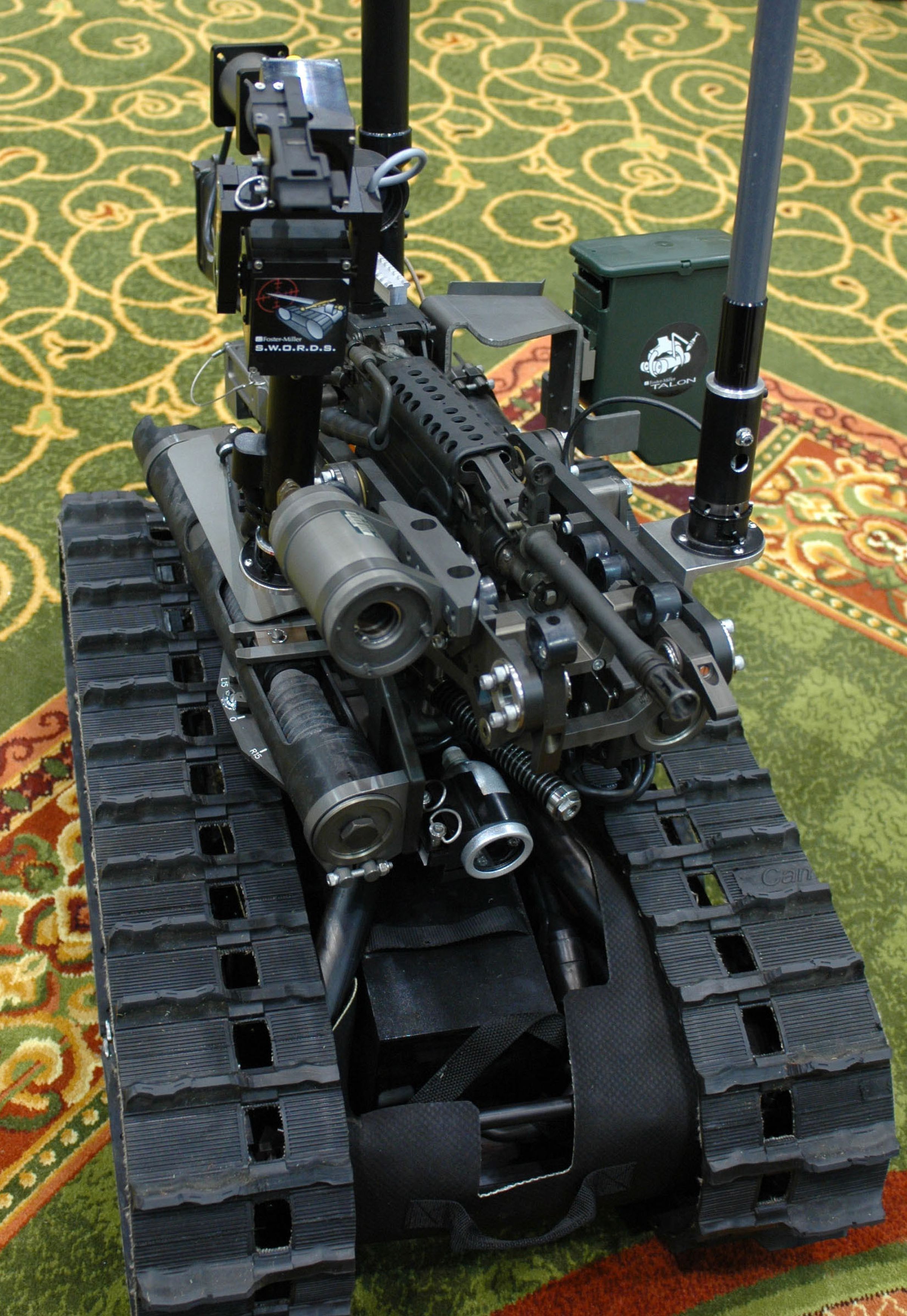 A picture showing a tracked robot the size of a small refrigerator armed with a gun.