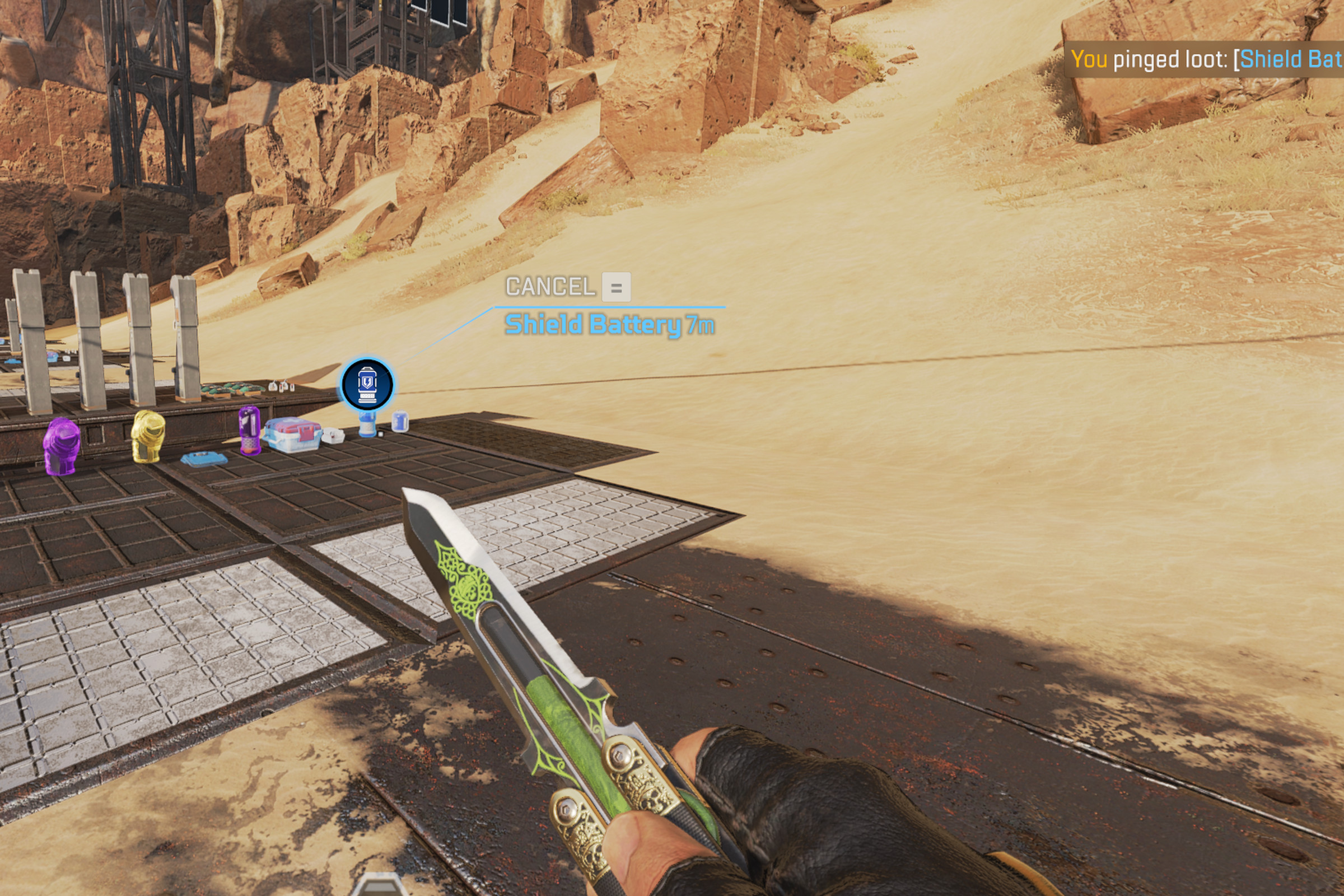 Screenshot of Apex Legends, showing a dessert landscape and a hand holding a knife, with text in the upper right corner that says “you pinged shield battery.”