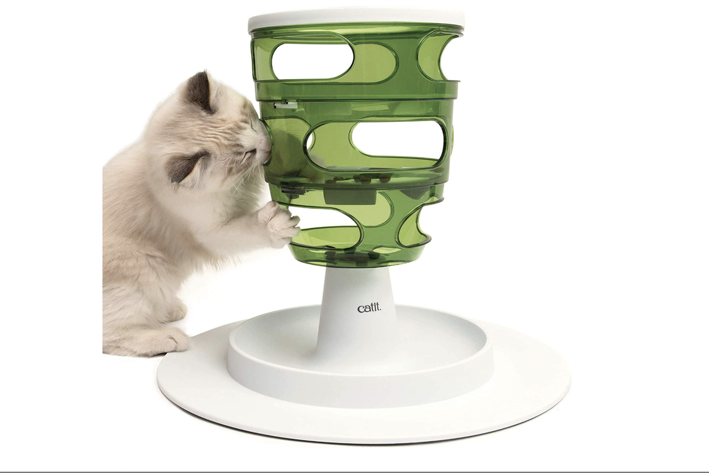 A cat tries to get into a tall plastic tower with openings for food.