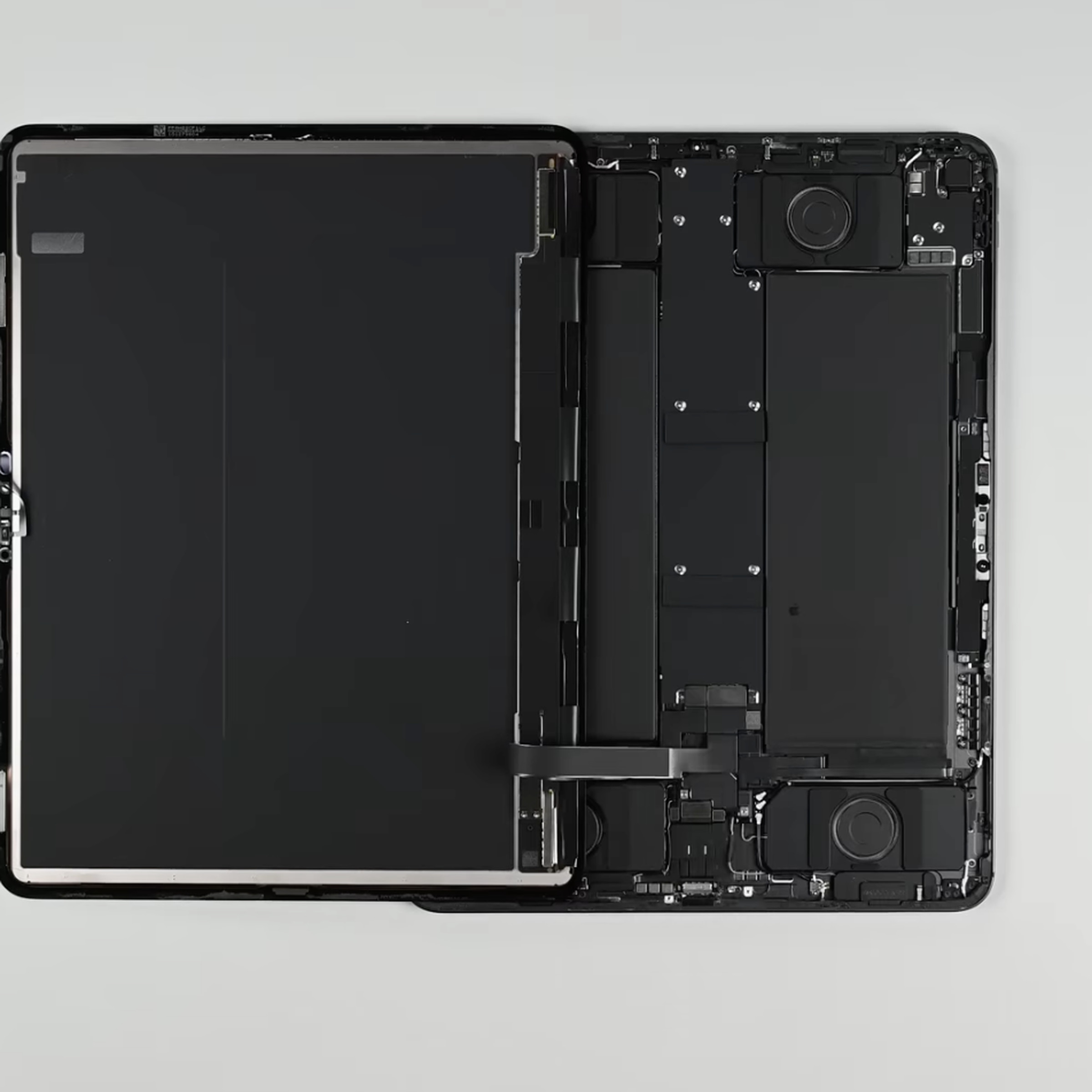 13-inch iPad Pro with screen removed and laying partially on top of it.