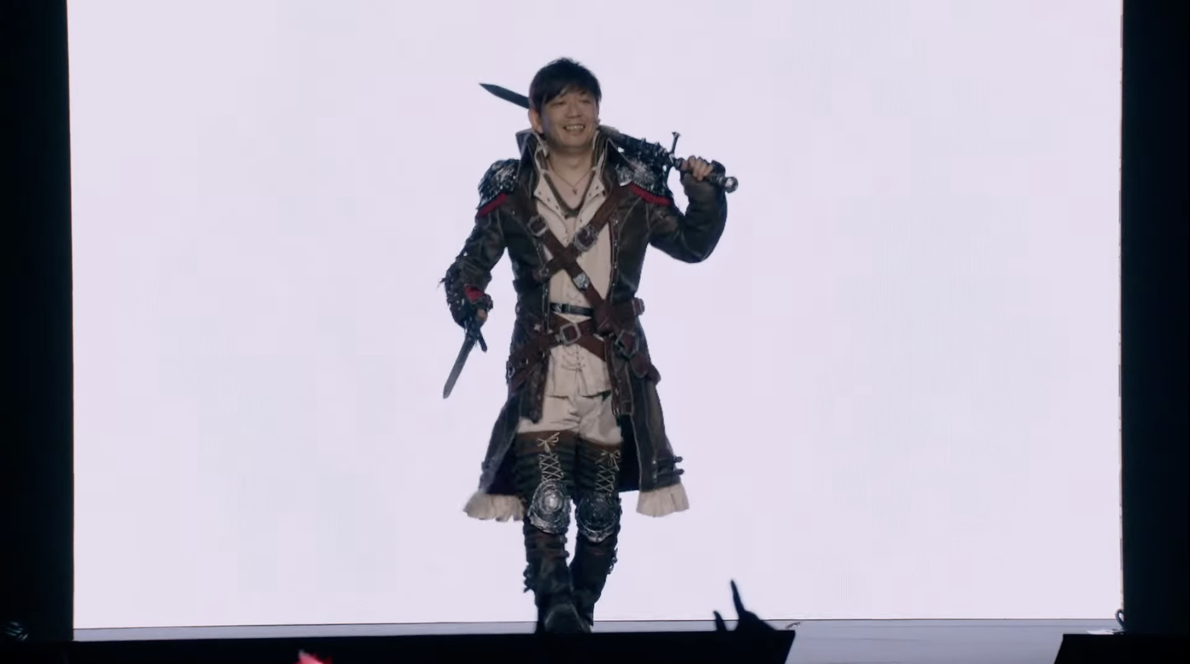 Image of FFXIV game producer Naoki Yoshida dressed as the new DPS class Viper at the 2023 Final Fantasy Fan Festival in London.