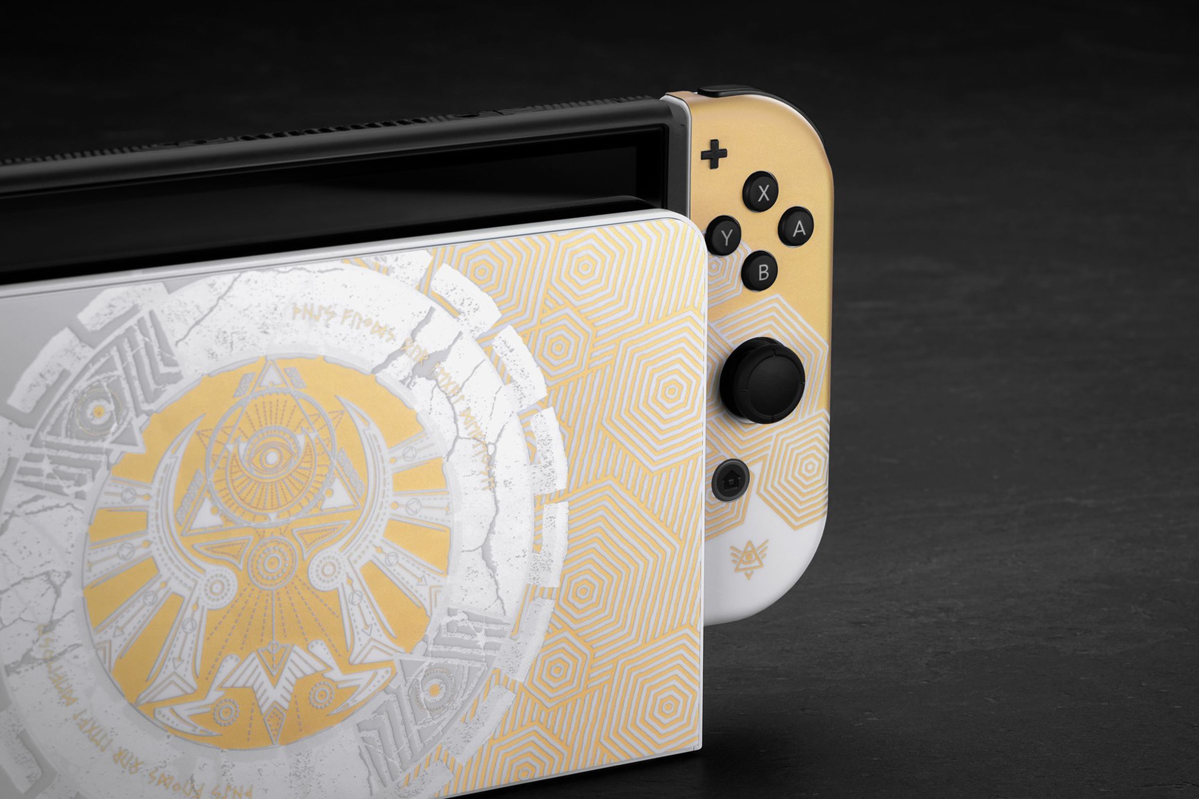 A gold and white skin on a Nintendo Switch that seems Zelda themed, but with an eye in a pyramid and concentric hexagons instead of concentric circles.