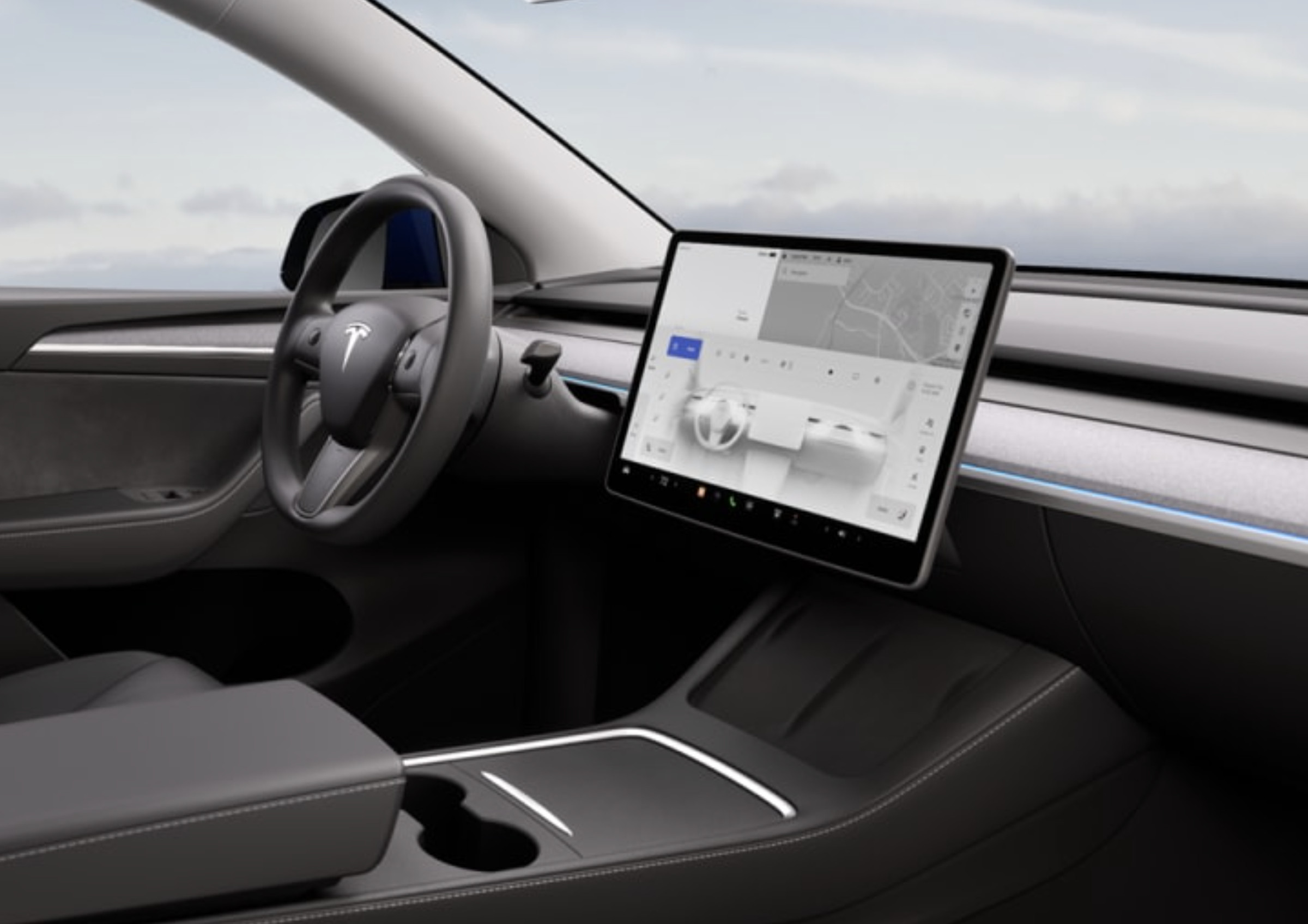 A picture of the interior of the new Model Y, showing the LED strip, steering wheel, and display.