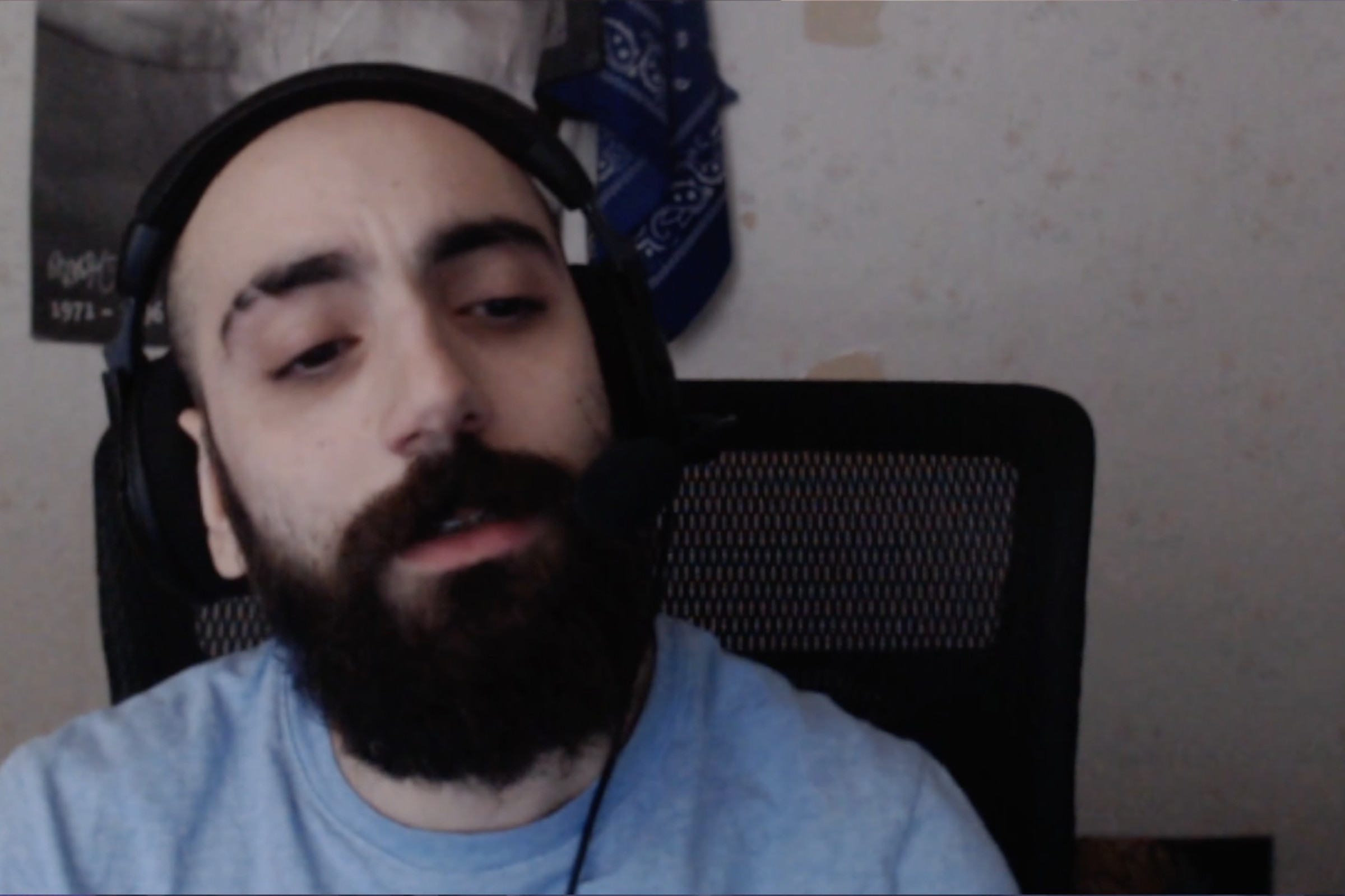 Screenshot from Sliker’s stream featuring a fair-skinned Middle Eastern man with a bald head and a full beard wearing thick earphones tearfully confessing his gambling addiction